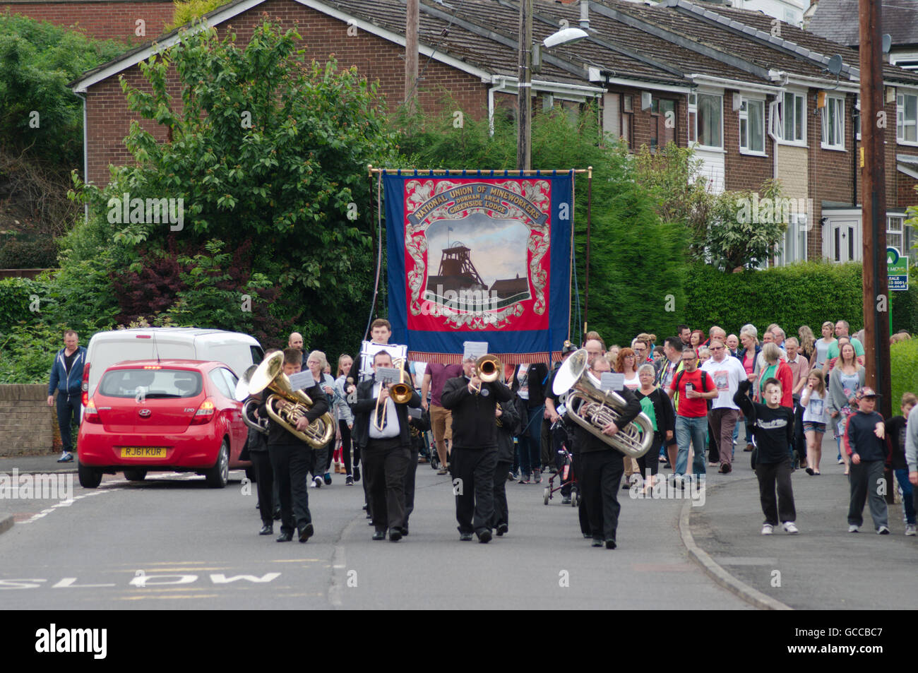 Greenside, UK, 9 July 2016. Drighlington Brass Band lead the pit banner