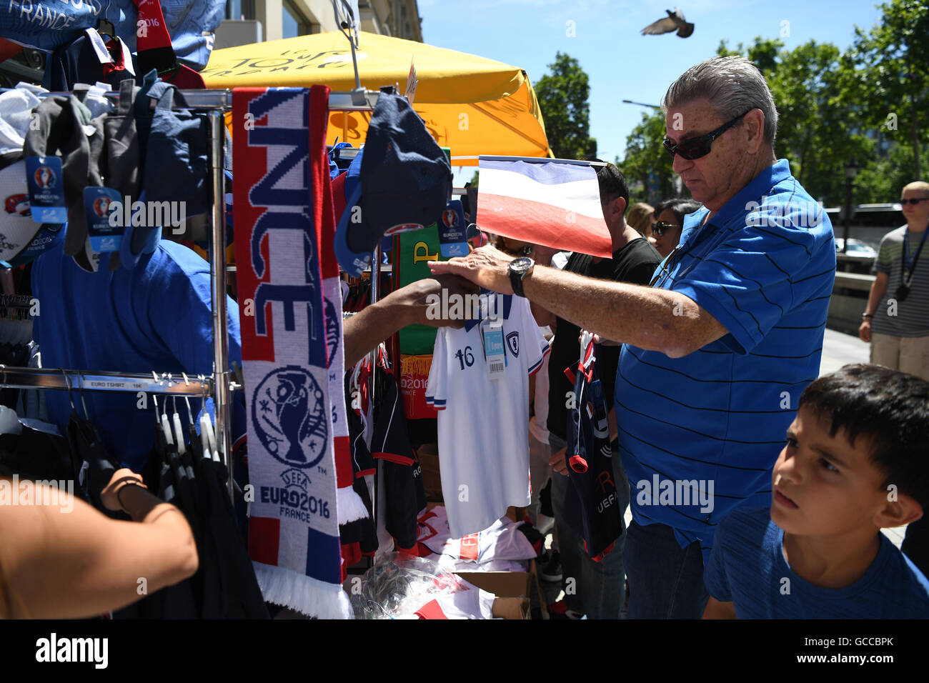 Paris, France. 09th July, 2016. A man looks at merchandise products of the French team at a souvenir shop at the Avenue des Champs-Elysees in Paris, France, 09 July 2016. Portugal face France in the UEFA EURO 2016 soccer Final match on 10 July 2016. Photo: Federico Gambarini/dpa/Alamy Live News Stock Photo