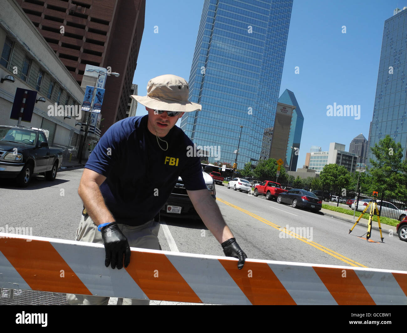 Dallas, US. 8th July, 2016. AN FBI officer closes off a street, on which stands a tripod, in the centre of Dallas, US, 8 July 2016. Probably out of hatred towards white people, at least five policemen have been shot in the US town of Dallas during a protest march against police violence. At least seven policemen and two civilians have been injured according to a statement made by the Texanian town's local authorities on Friday. Photo: Johannes Schmitt-Tegge/dpa/Alamy Live News Stock Photo