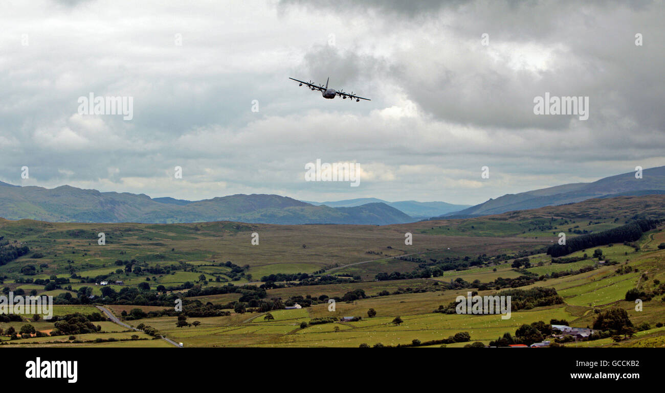 A US Hercules plane flies through the Machynlleth Loop in Wales, a series of valleys notable for their use as low-level training areas for fast jet aircraft. Stock Photo
