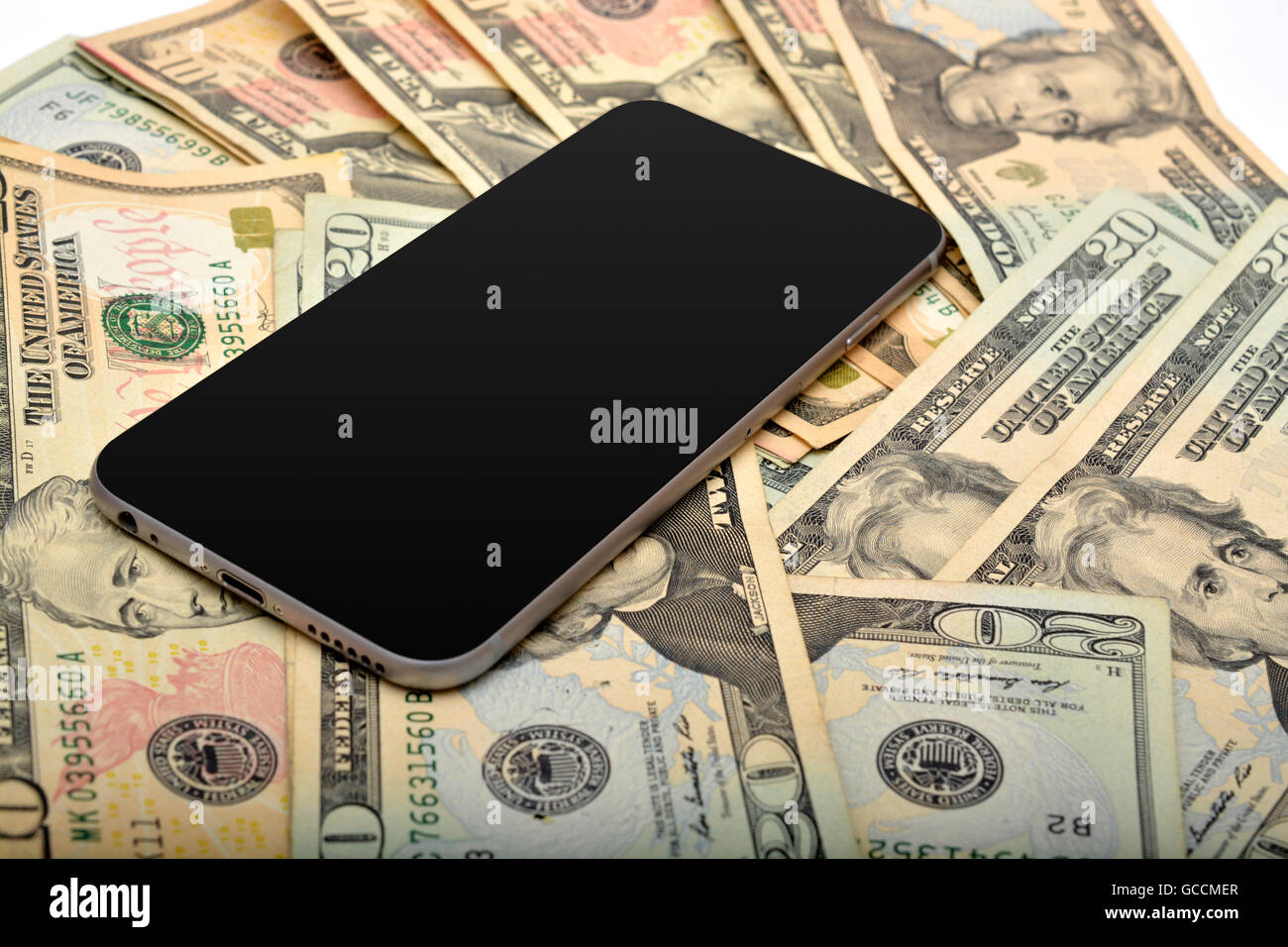 Smart phone with dollars in background. Stock Photo