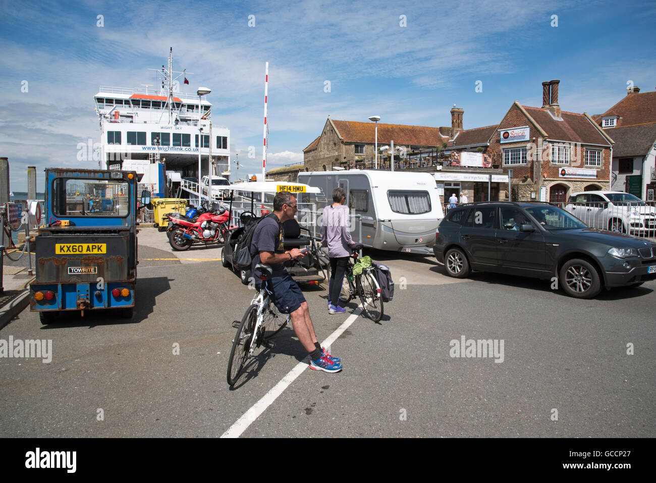 YARMOUTH HARBOUR ISLE OF WIGHT - Cyclists waiting to board a roll on roll off ferry berthed on the waterfront Stock Photo