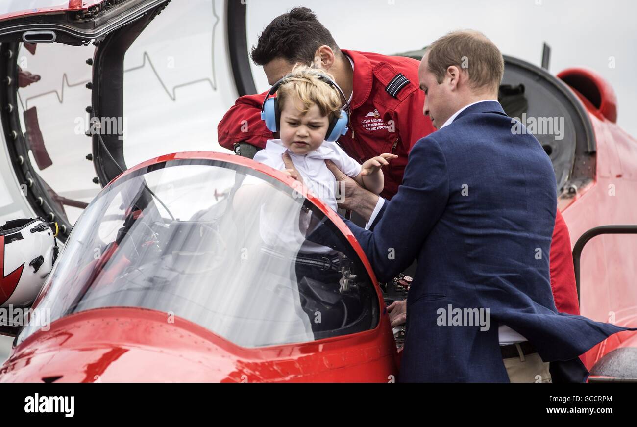 Prince George is lifted from the cockpit of a Red Arrows plane by his father the Duke of Cambridge during a visit to the Royal International Air Tattoo at RAF Fairford - the world's largest military airshow. Stock Photo