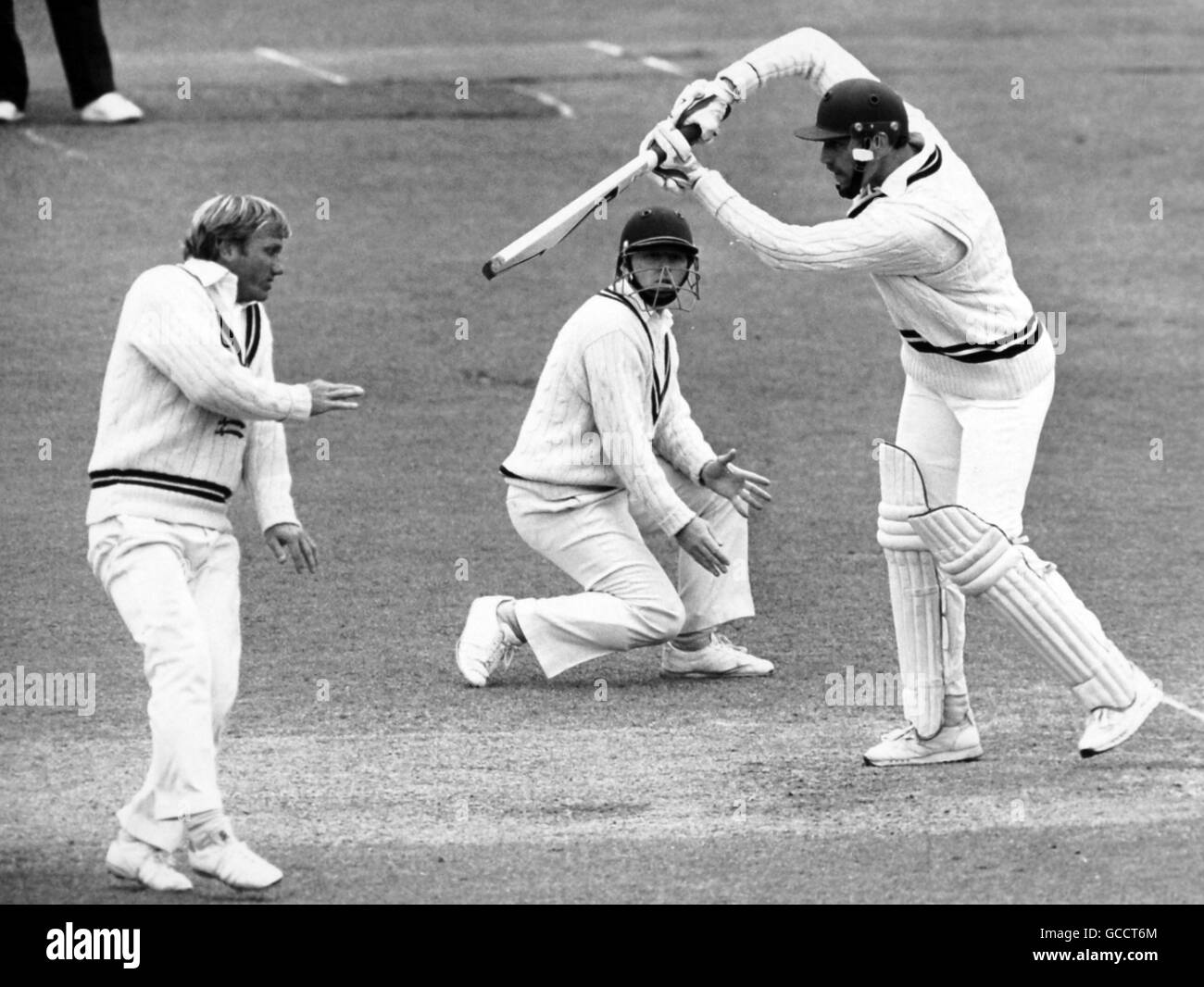 Worcestershire batsman David Smith drives the ball past Middlesex fielder Clive Radley (left) watched on by Middlesex fiedler Keith Tomlins (centre) Stock Photo