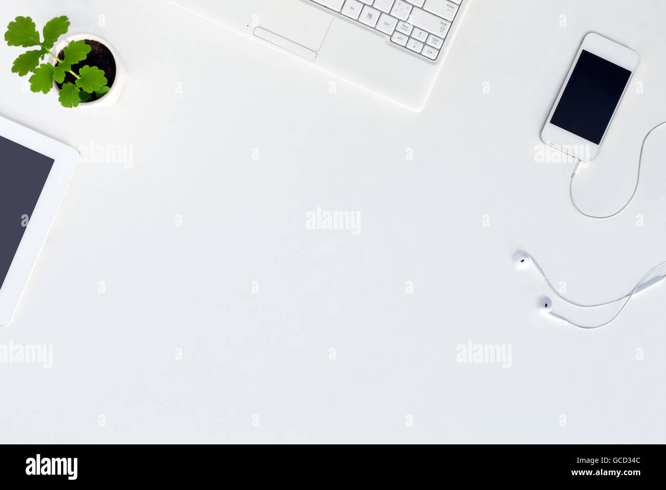 Top View of trendy White Office Desk with white Electronics and green