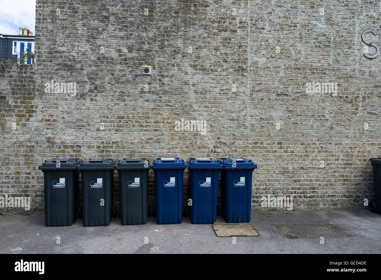 Recycling bins against brick wall hires stock photography and images