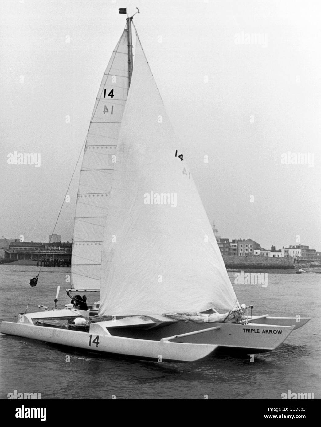 AJAX NEWS PHOTOS. 4TH MAY, 1974. PORTSMOUTH,ENGLAND. - BANK MANAGER SAILOR - BRIAN COOKE AND HIS CREW ERIC JENSEN SAILING THE TRIMARAN TRIPLE ARROW.  PHOTO:JONATHAN EASTLAND/AJAX REF:TRIPLE ARROW 1974 2 NOTE** FEBRUARY 20, 1976. LONE SAILOR FEARED DROWNED - 54 YEAR OLD BANK MANAGER BRIAN COOKE OF PARKSTONE, DORSET WAS FEARED DROWNED TODAY AFTER HIS TRIMARAN TRIPLE ARROW WAS FOUND CAPSIZED 450 MILES WEST OF CANARY ISLANDS BY A NORWEGIAN BULK CARRIER.  COOKE, A VETERAN OCEAN RACER, SET SAIL FROM PLYMOUTH,ENGLAND ON DECEMBER 7/75 ON HIS SECOND ATTEMPT TO BEAT THE ATLANTIC SPEED AND DISTANCE TRIAL Stock Photo