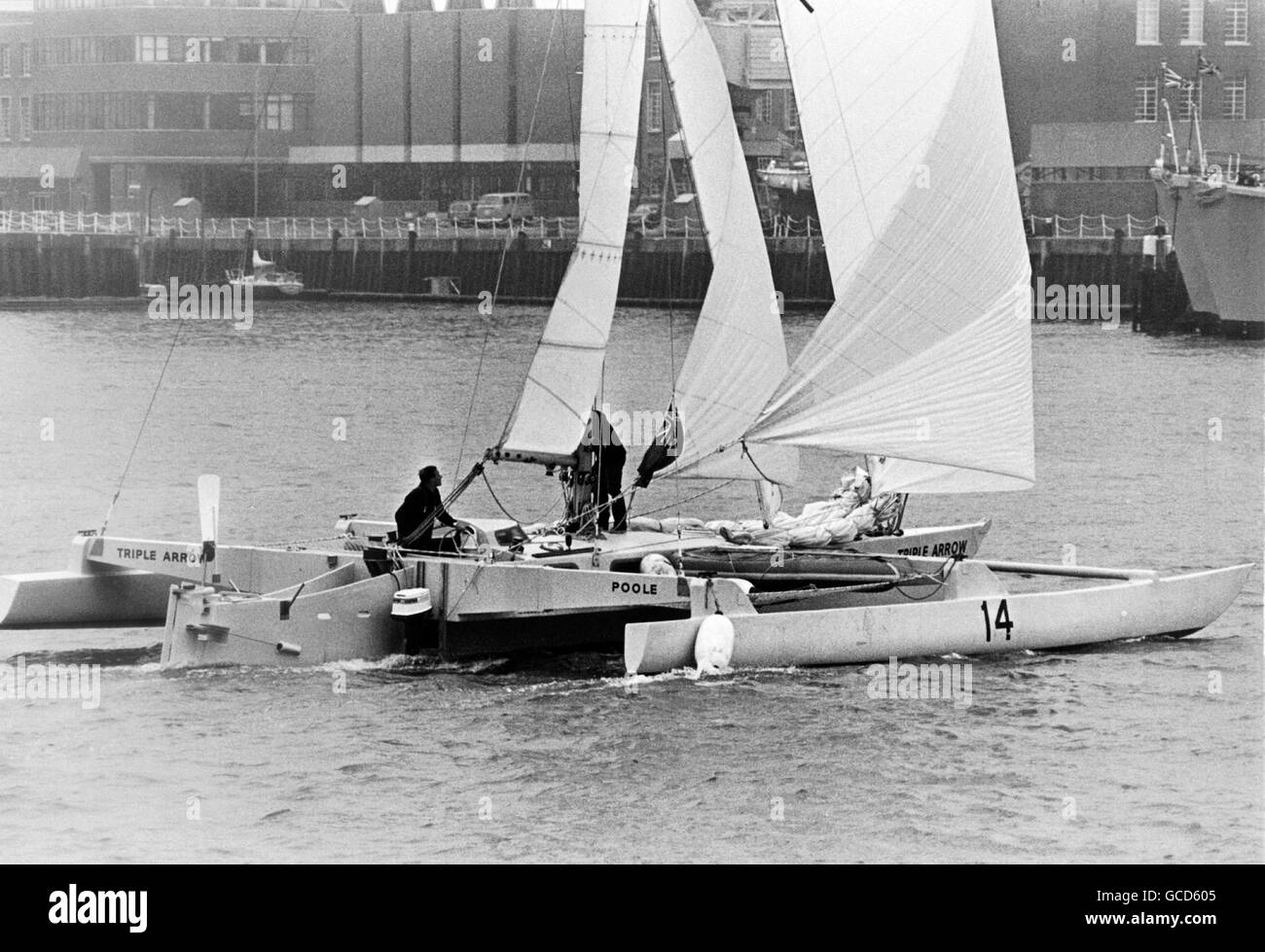 AJAX NEWS PHOTOS. 4TH MAY, 1974. PORTSMOUTH,ENGLAND. - BANK MANAGER SAILOR - BRIAN COOKE AND HIS CREW ERIC JENSEN SAILING THE TRIMARAN TRIPLE ARROW.  PHOTO:JONATHAN EASTLAND/AJAX REF:TRIPLE ARROW 1974 1 NOTE** FEBRUARY 20, 1976. LONE SAILOR FEARED DROWNED - 54 YEAR OLD BANK MANAGER BRIAN COOKE OF PARKSTONE, DORSET WAS FEARED DROWNED TODAY AFTER HIS TRIMARAN TRIPLE ARROW WAS FOUND CAPSIZED 450 MILES WEST OF CANARY ISLANDS BY A NORWEGIAN BULK CARRIER.  COOKE, A VETERAN OCEAN RACER, SET SAIL FROM PLYMOUTH,ENGLAND ON DECEMBER 7/75 ON HIS SECOND ATTEMPT TO BEAT THE ATLANTIC SPEED AND DISTANCE TRIAL Stock Photo