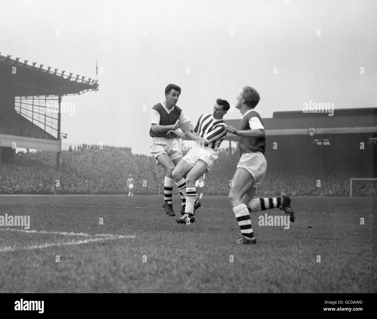 West Bromwich Albion's Bobby Robson (striped shirt) intrudes between John Barnwell and Bill Dodgin of Arsenal. Stock Photo