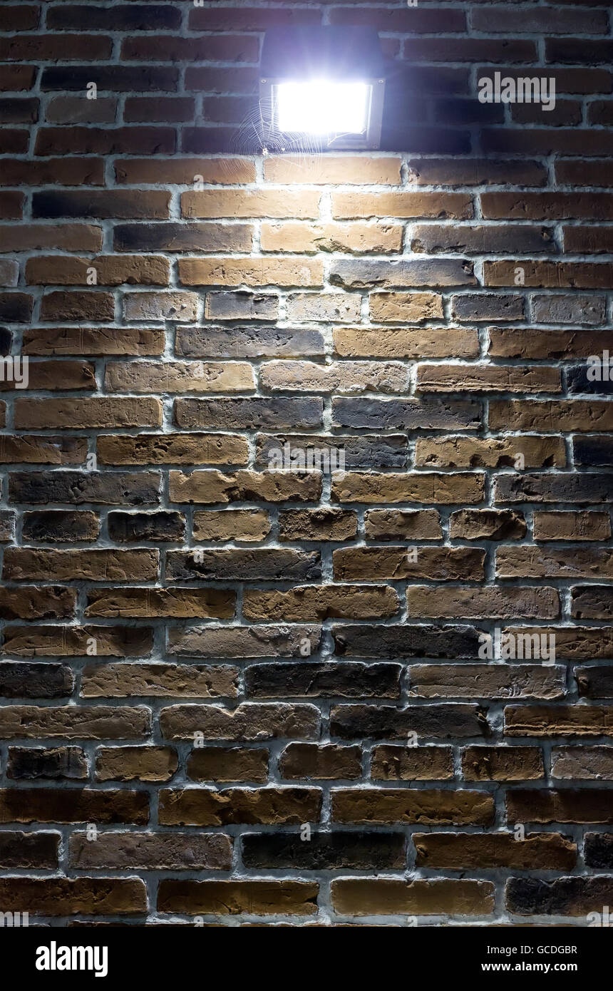 spotlight on rough red brick wall at night Stock Photo