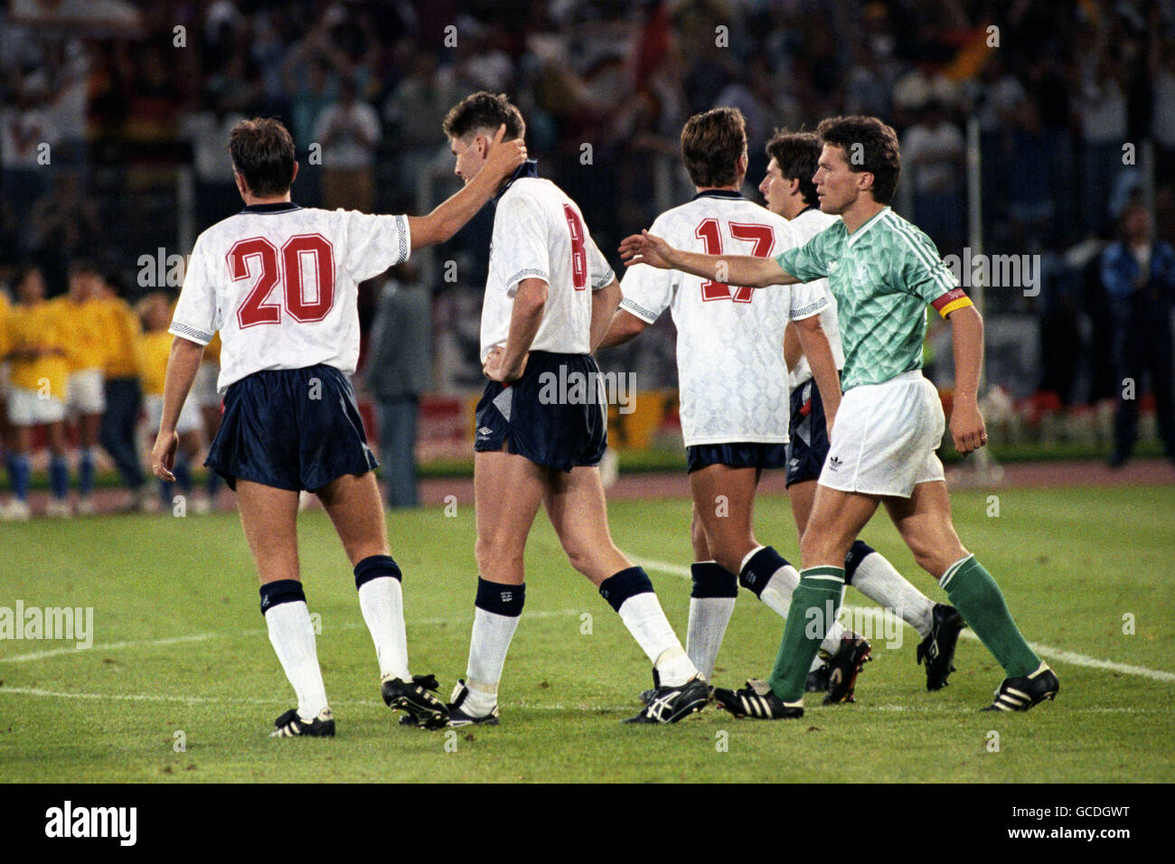 West Germany captain Lothar Mathaus (r) and England's Gary Lineker (l) console Chris Waddle after his penalty miss during the shootout Stock Photo