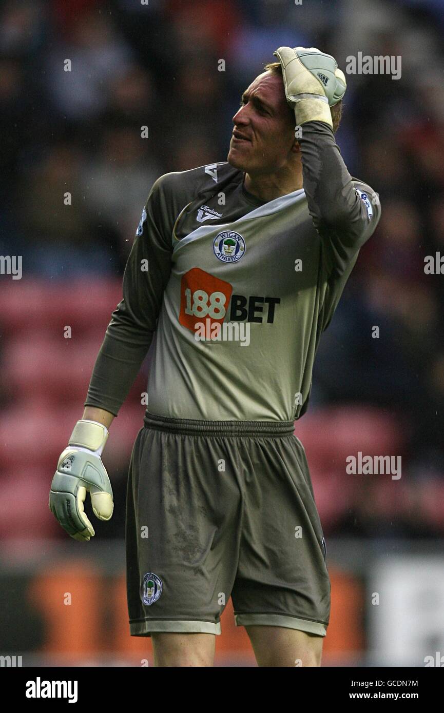 Wigan Athletic goalkeeper Chris Kirkland holds his head after being hit