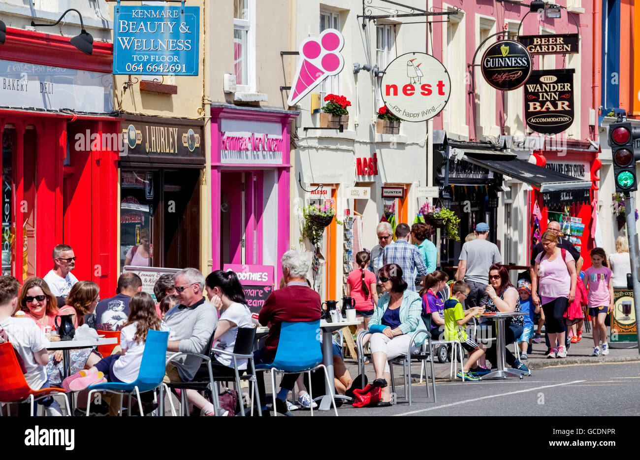 Customers sitting at tables along the street outside shops; Kenmare, County Kerry, Ireland Stock Photo