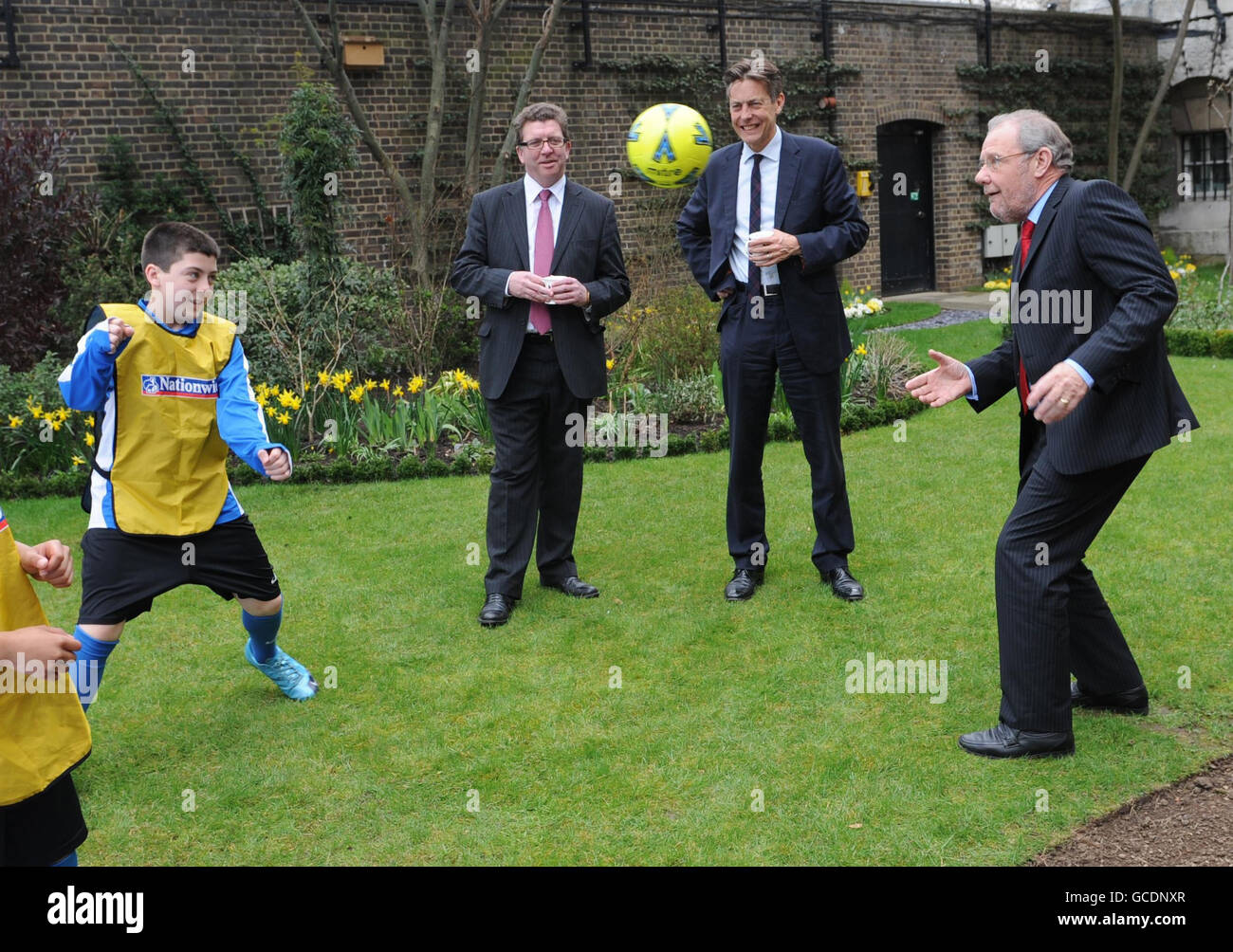 RE-TRANSMISSION AMENDING THE SPELLING OF GERRY SUTCLIFFE. 2018 World Cup bid Ambassador Richard Caborn MP throws a football in the garden of 10 Downing Street, London, with Sports Minster Gerry Sutcliffe (left) and Culture Minister Ben Bradshaw, where they and Prime Minister Gordon Brown signed a giant England shirt to show their support for the England world cup team this year. Stock Photo