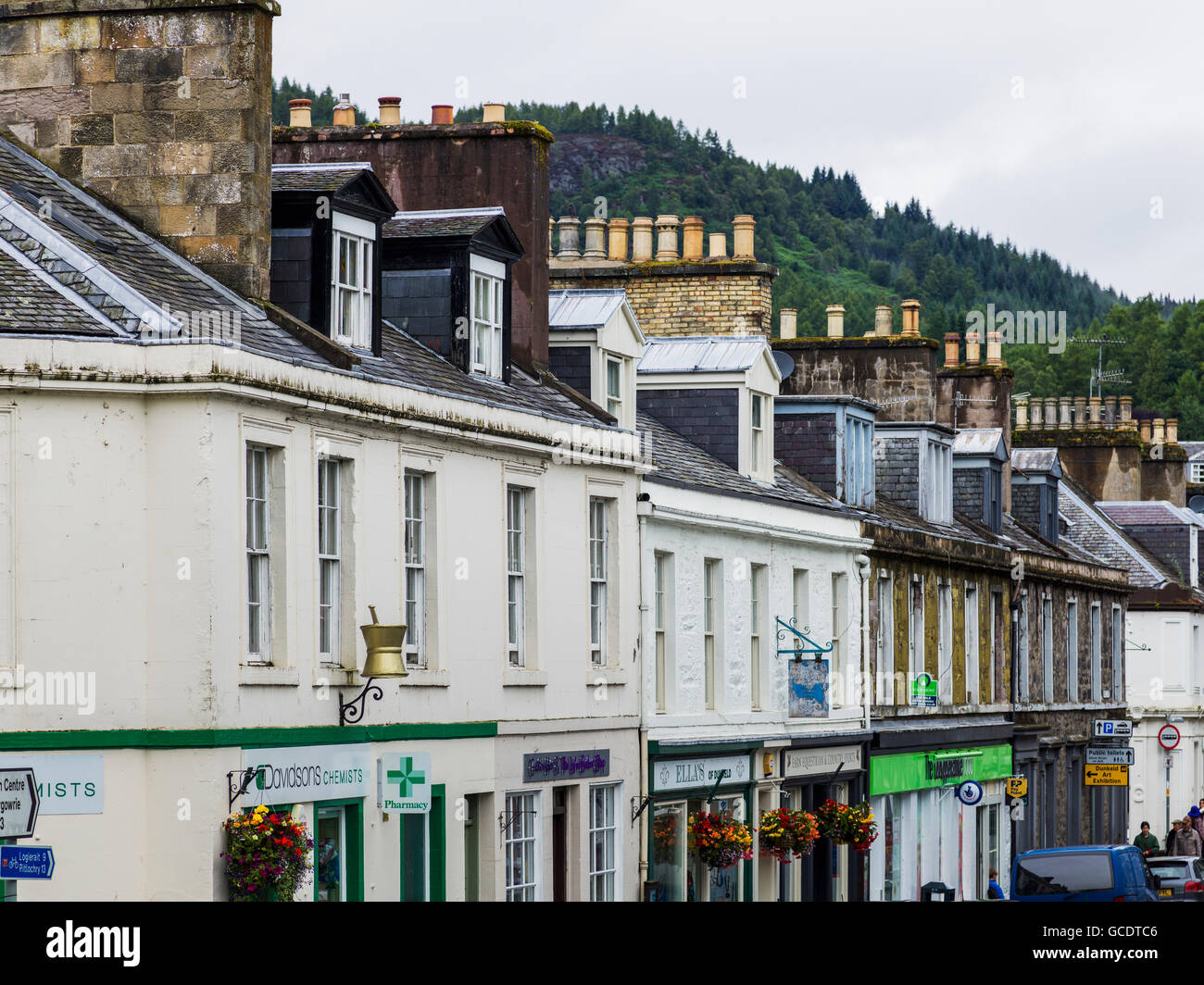 Buildings with shops and chimneys on the rooftops in a row; Dunkeld, Perth and Kinross, Scotland Stock Photo