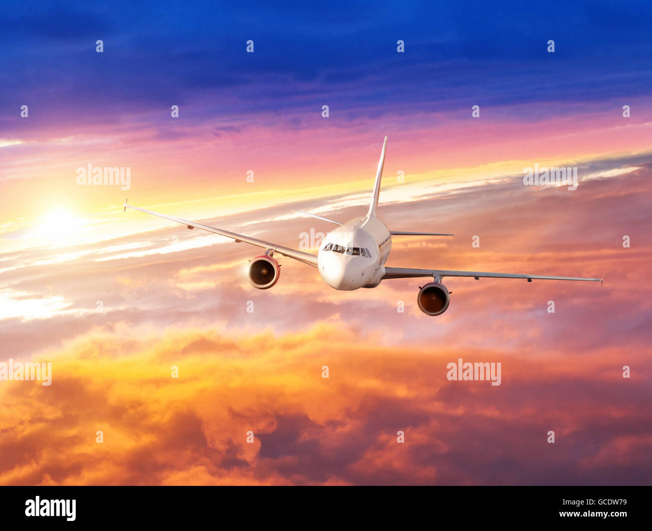 Commercial airplane flying above clouds in dramatic sunset light Stock ...