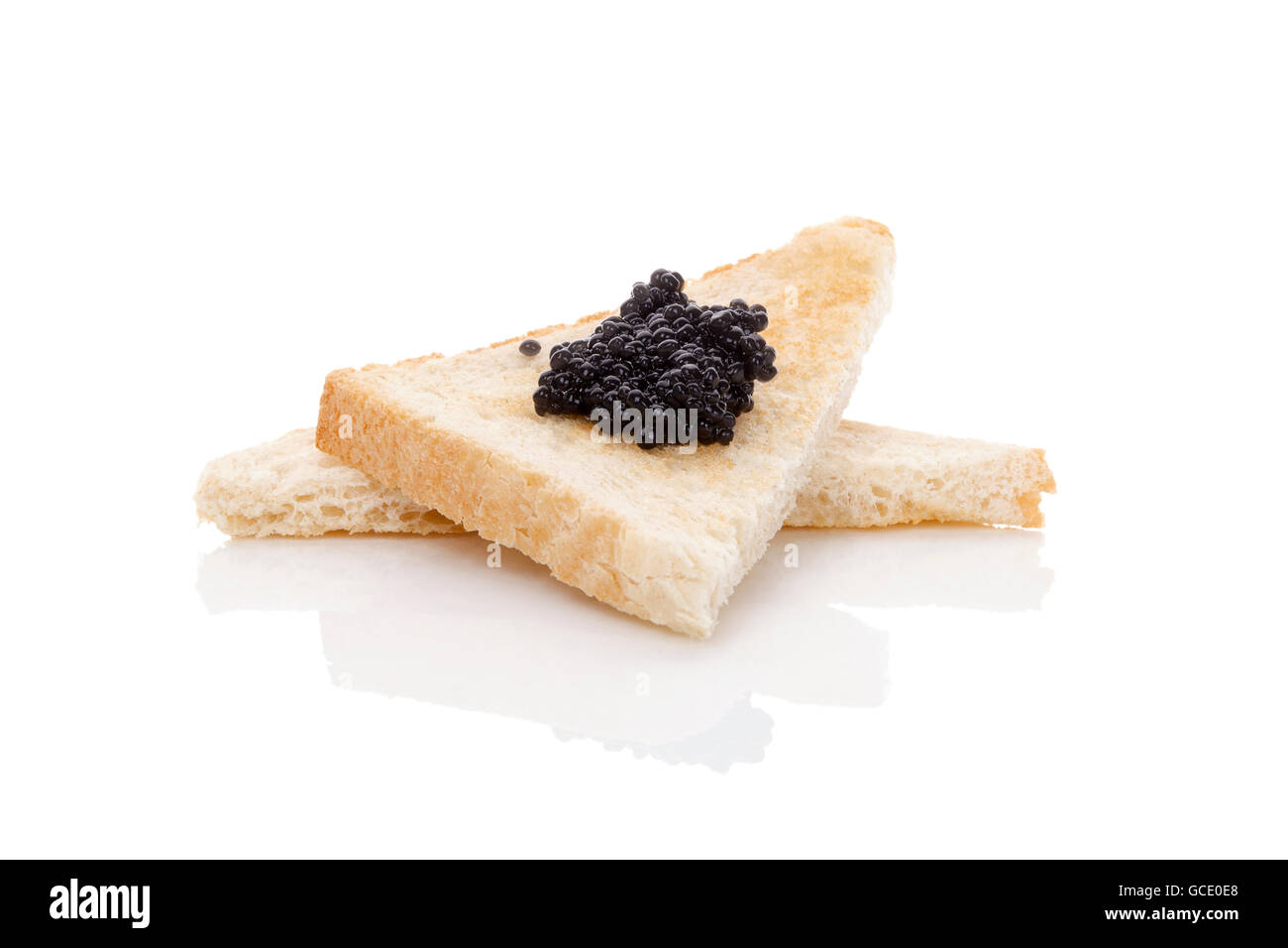 Delicious black caviar on toast isolated on white background. Exquisite luxurious gourmet eating. Stock Photo