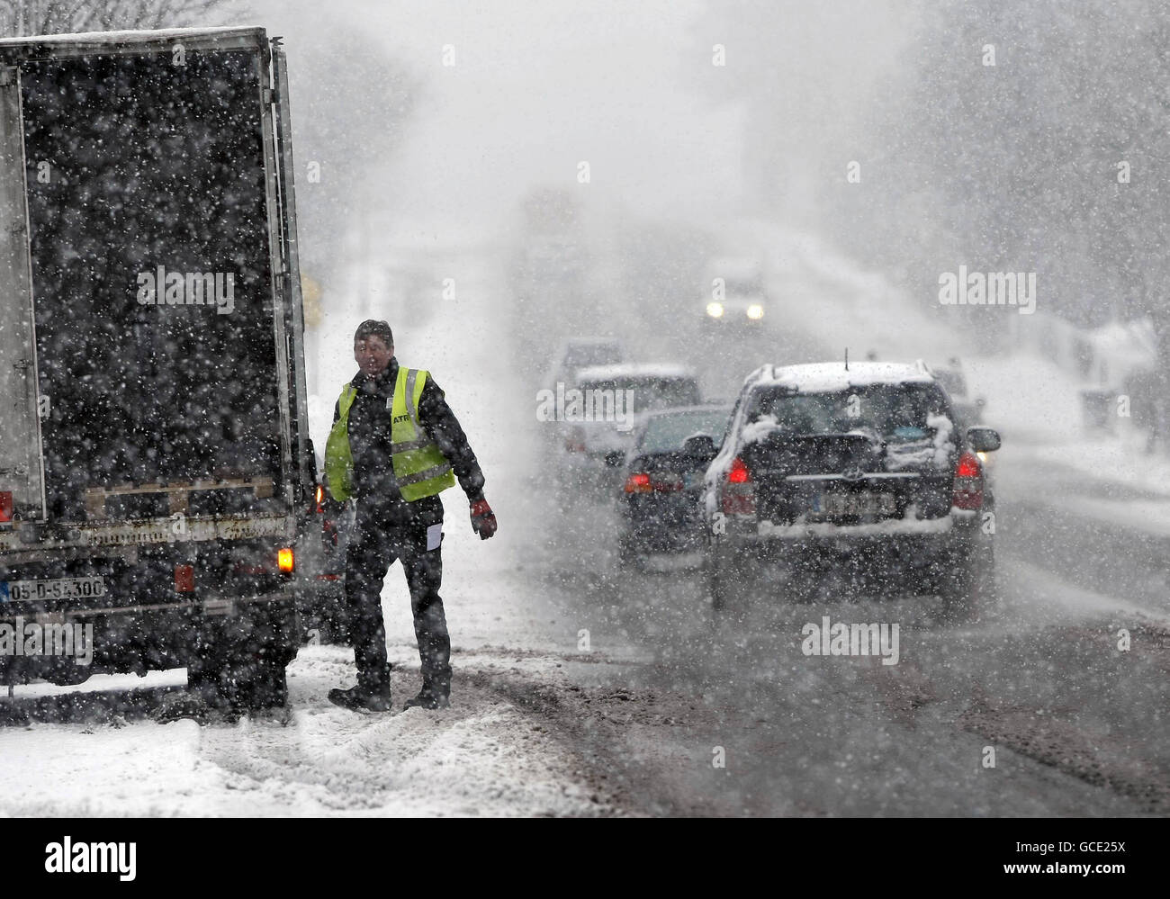 A delivery man works in heavy snow in Cavan town, Ireland, as the snow and rain made driving conditions treacherous and further sleet and snow is expected. Stock Photo
