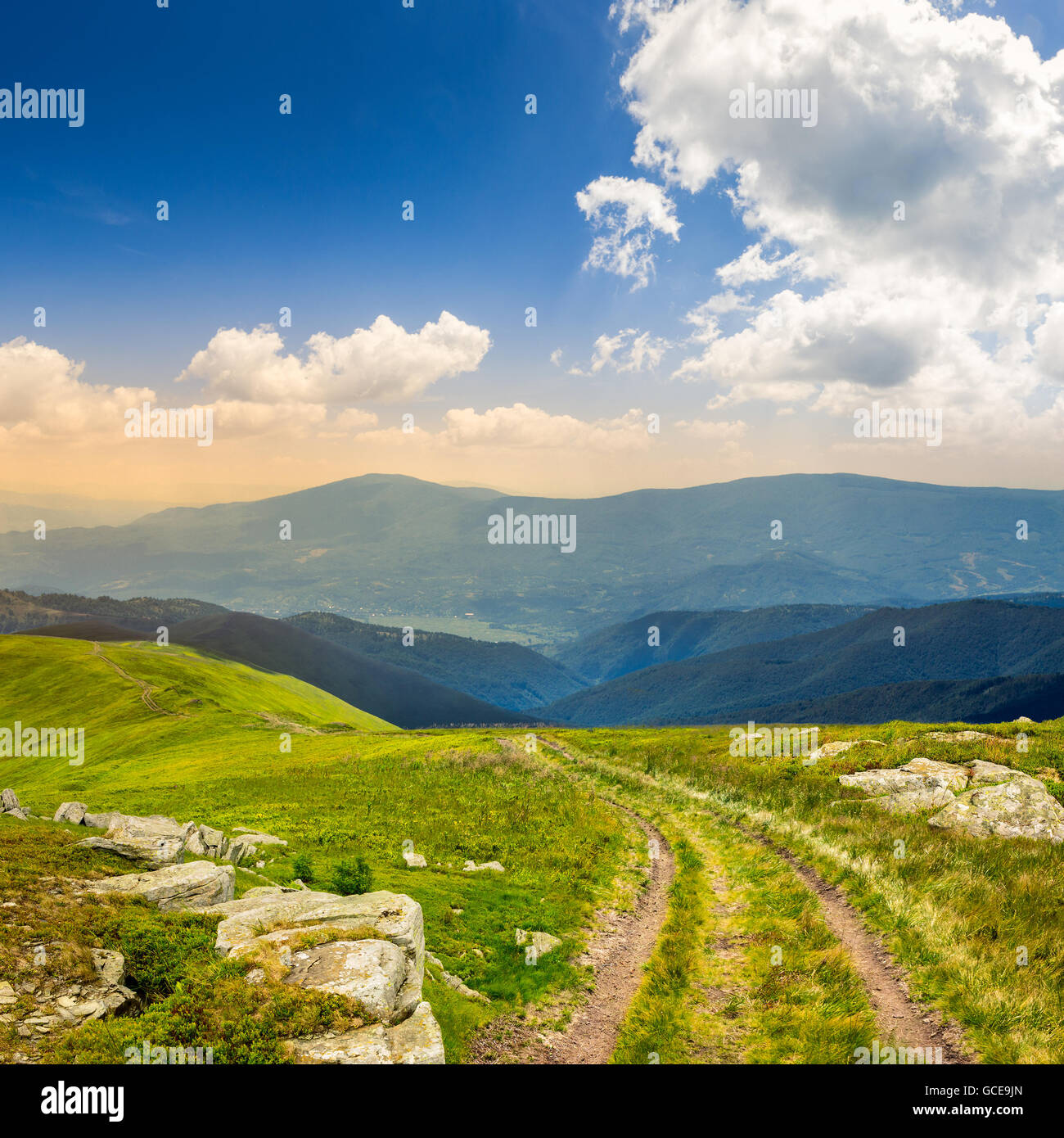 road among white sharp stones on the hillside on top of mountain range ...