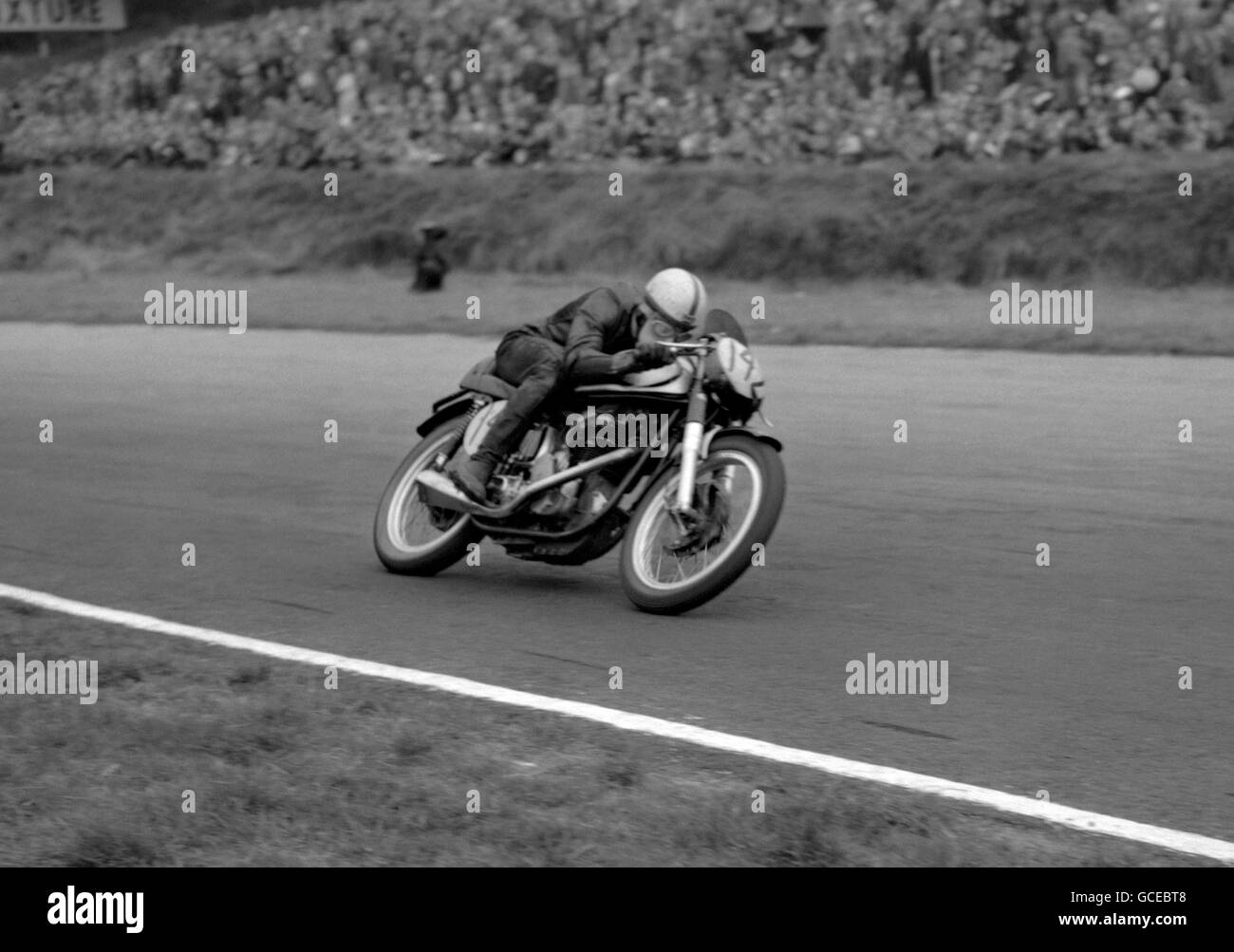 Brilliant youngster John Surtees streaks round Brands Hatch on his way to victory over World Motor Cycle champion Geoff Duke. Surtees, riding a Norton, triumphed in an exciting duel during the non-championship event Stock Photo