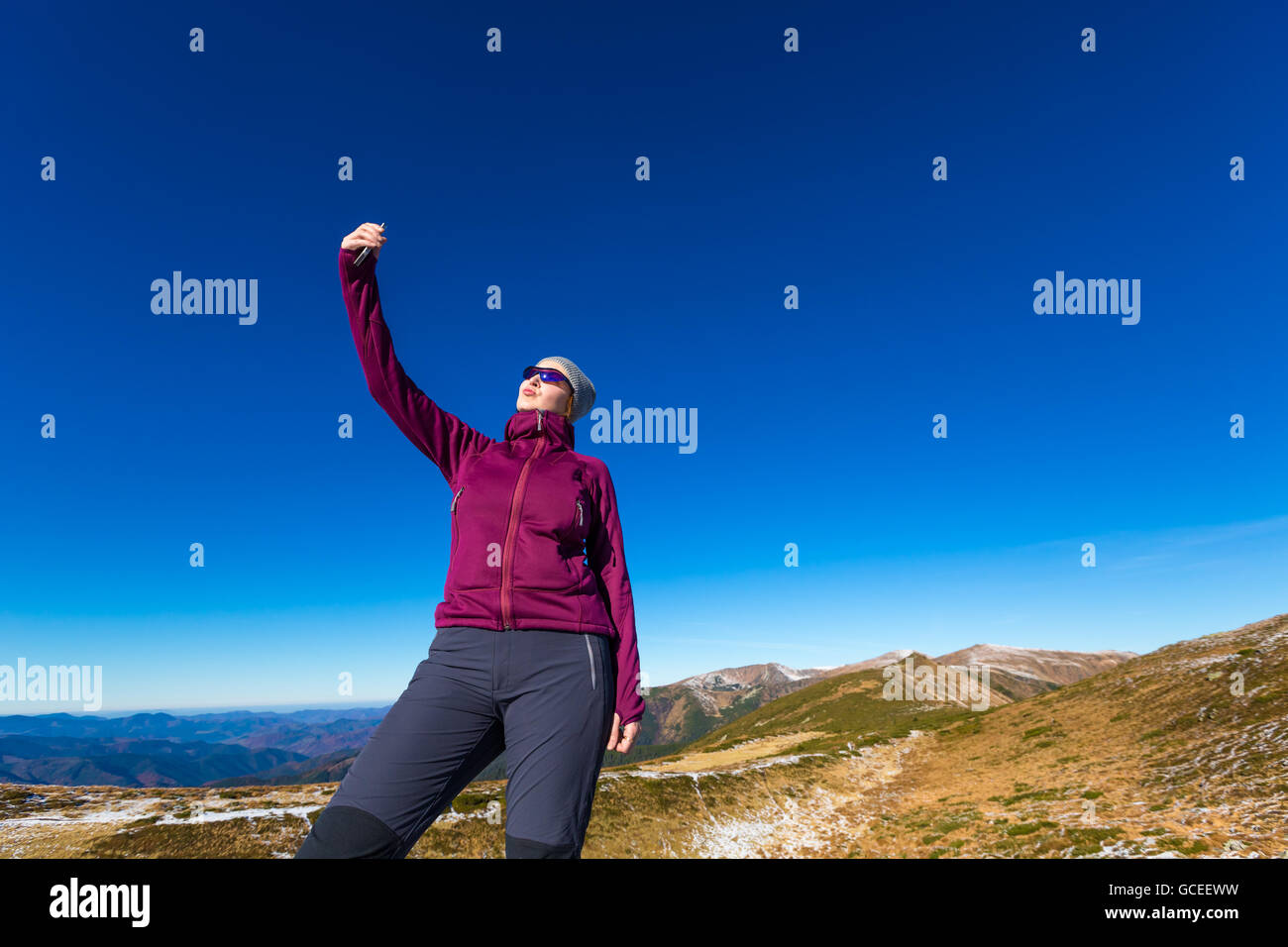 Elegant Female Hiker Making self portrait Selfie on mobile Phone Stock Photo