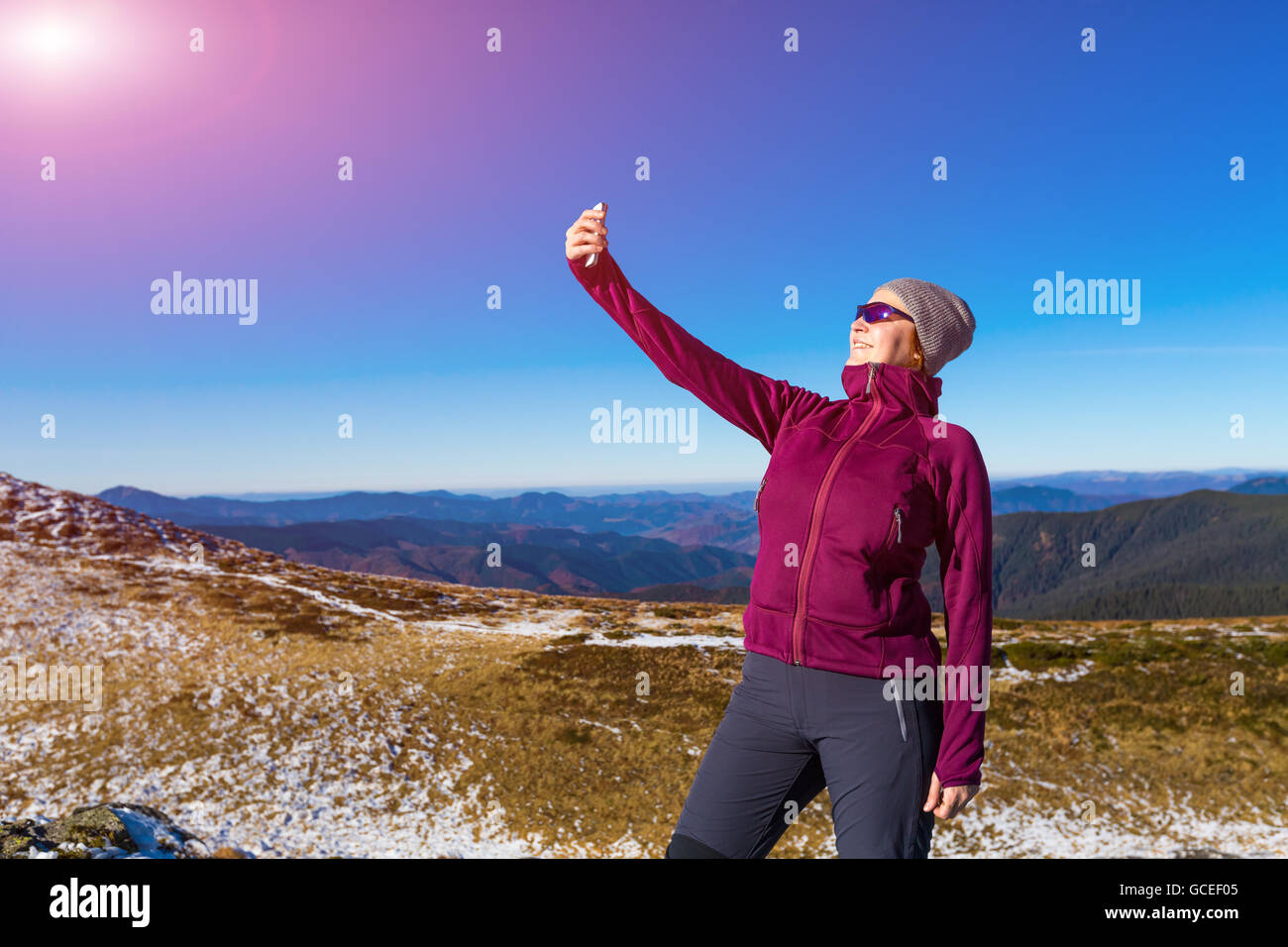 Cute Woman in sporty Clothing making self portrait selfie on mobile Phone Stock Photo