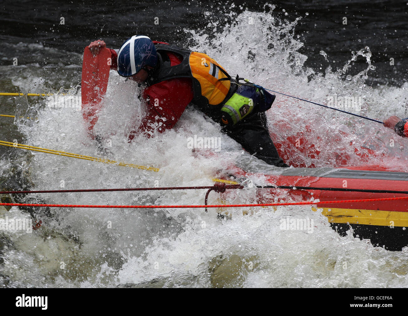 An emergency worker attempts to recover a kayak submerged under water