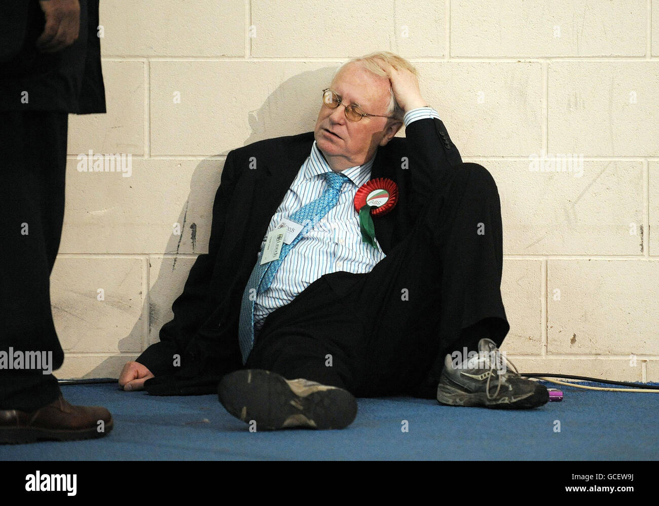 A supporter of the Alliance For Green Socialism party takes a rest during the Leeds electoral counts in the John Charles Sports Centre, Leeds. Stock Photo