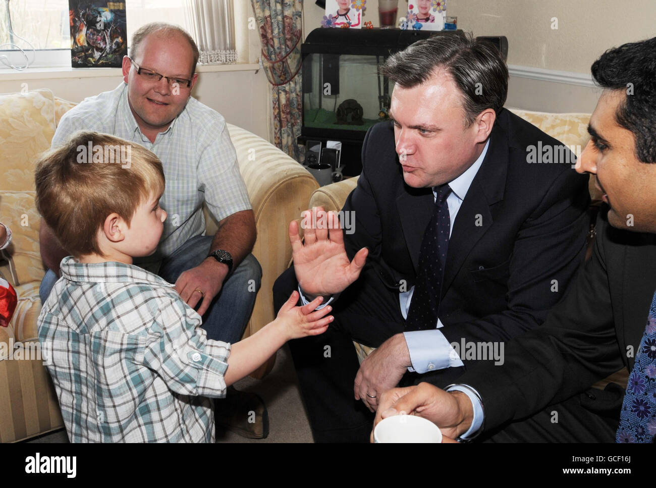 Ed Balls, Secretary of State for Children, Schools and Families meets William Chatterton, 3, as his father Chris Chatterton (left) looks on. Mr Balls was attending a house meeting in Gloucester with local parents and children who have benefited from Labour's Sure Start Children's Centres. Stock Photo