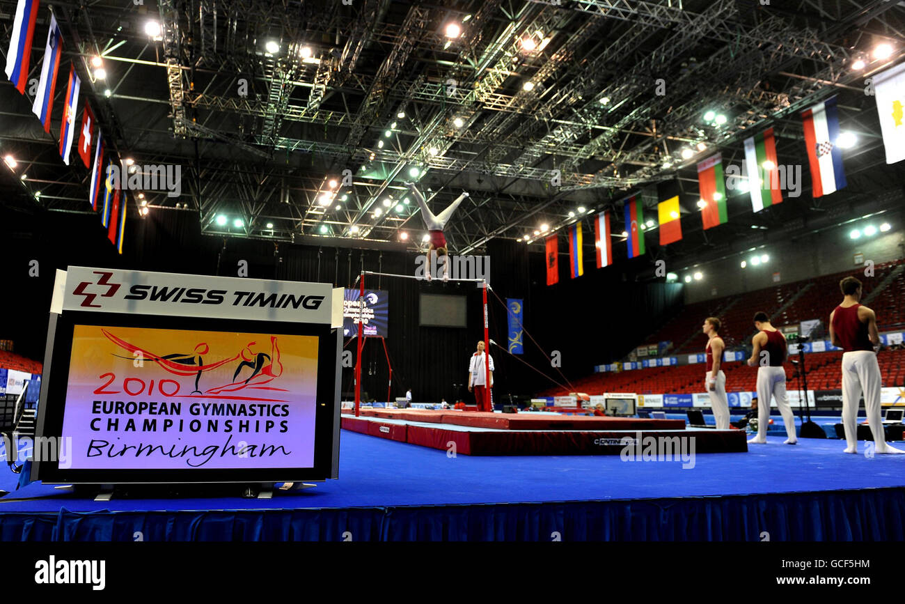 A gymnast practices on the high bar during practice day for the
