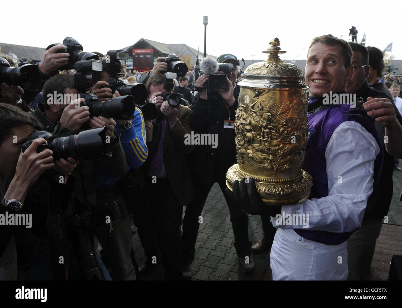Jockey Richard Johnson poses with the trophy in front of a packed crowd