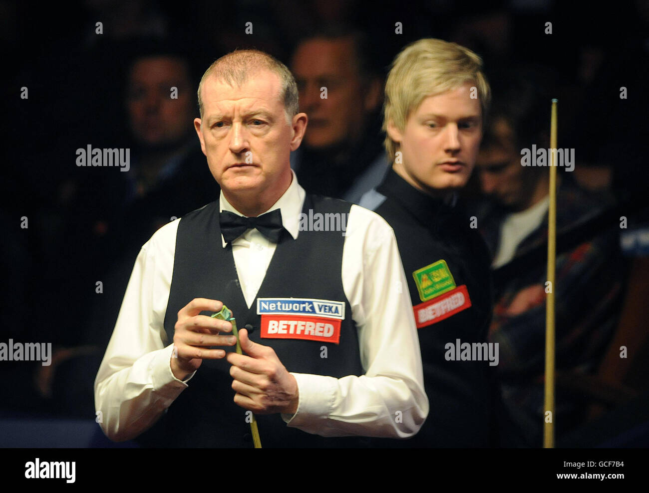 Steve Davis (left) studies the table in his match against Neil Robertson during the quarter finals of the Betfred World Snooker Championships at the Crucible Theatre, Sheffield Stock Photo