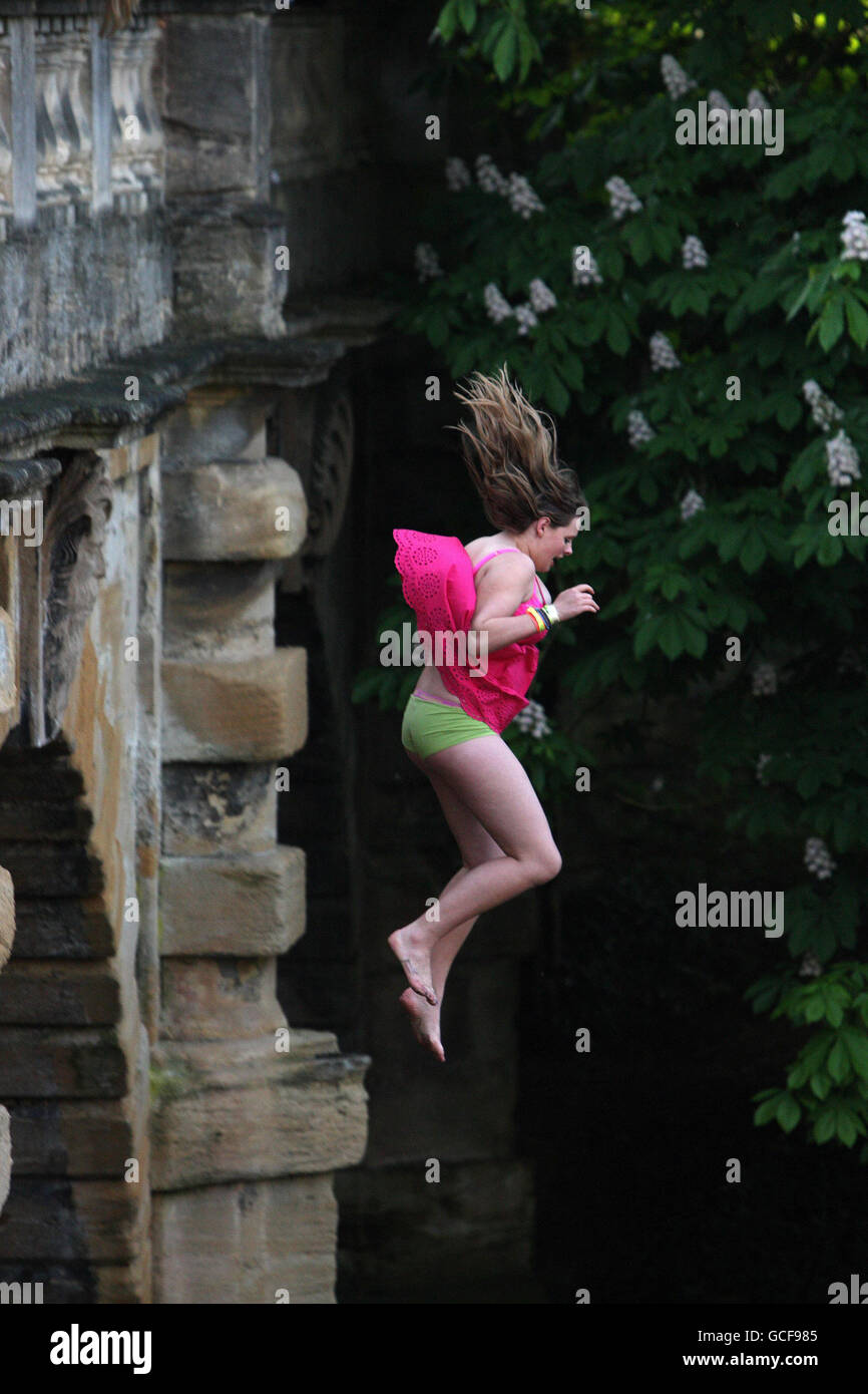 A girl jumps off Magdalen Bridge into the River Cherwell in Oxford, to celebrate May Day. Stock Photo