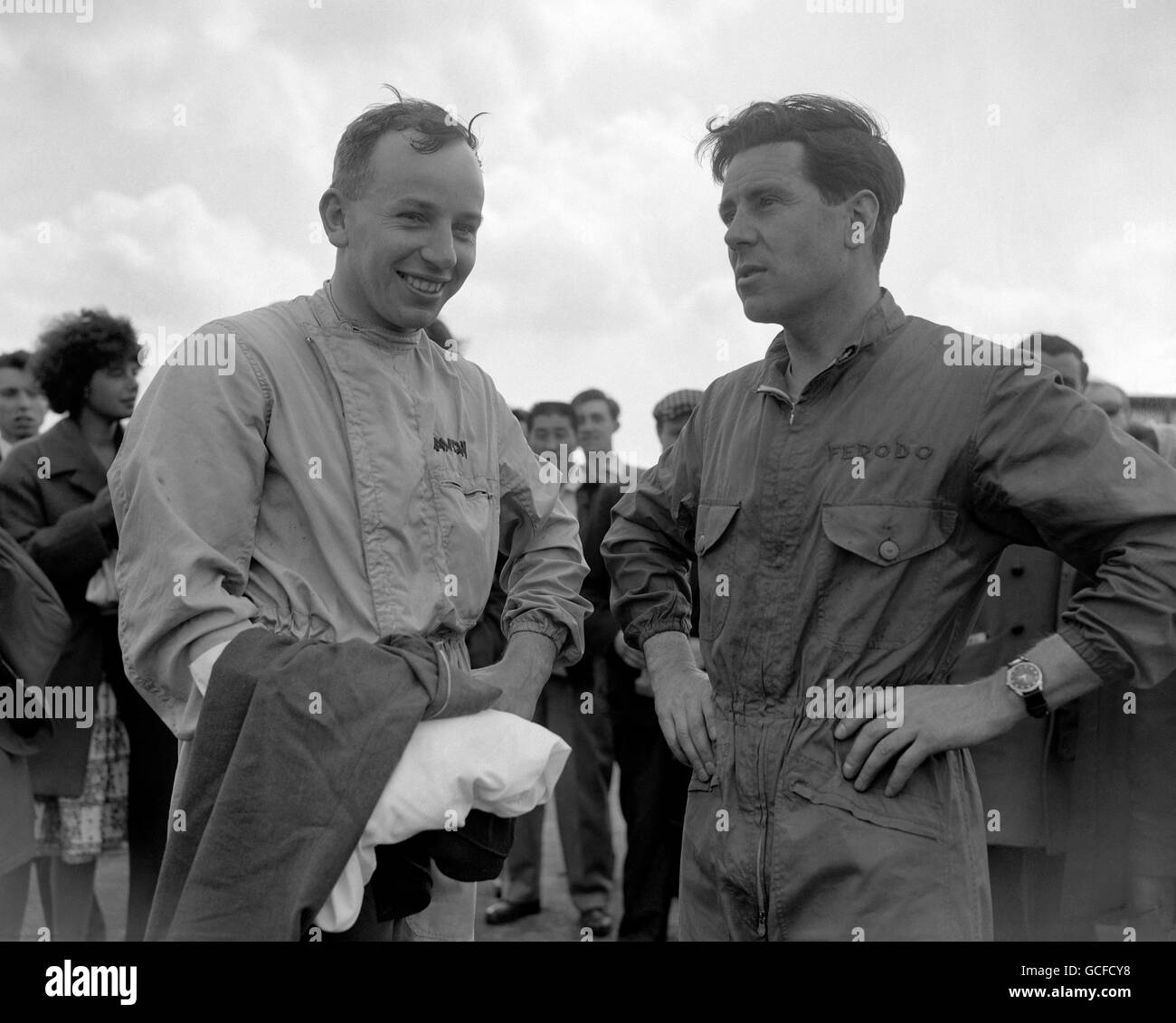 John Surtees (left) and Geoff Duke, who both had World motorcycling championships, are taking up motor car racing. They met at the Silverstone track in Northamptonshire, where both competed in the May 14th meeting. Stock Photo