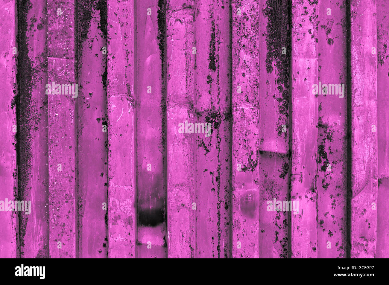 rough and rusty purple pink or purplish pinkish violet corrugated iron metal surface close-up Stock Photo