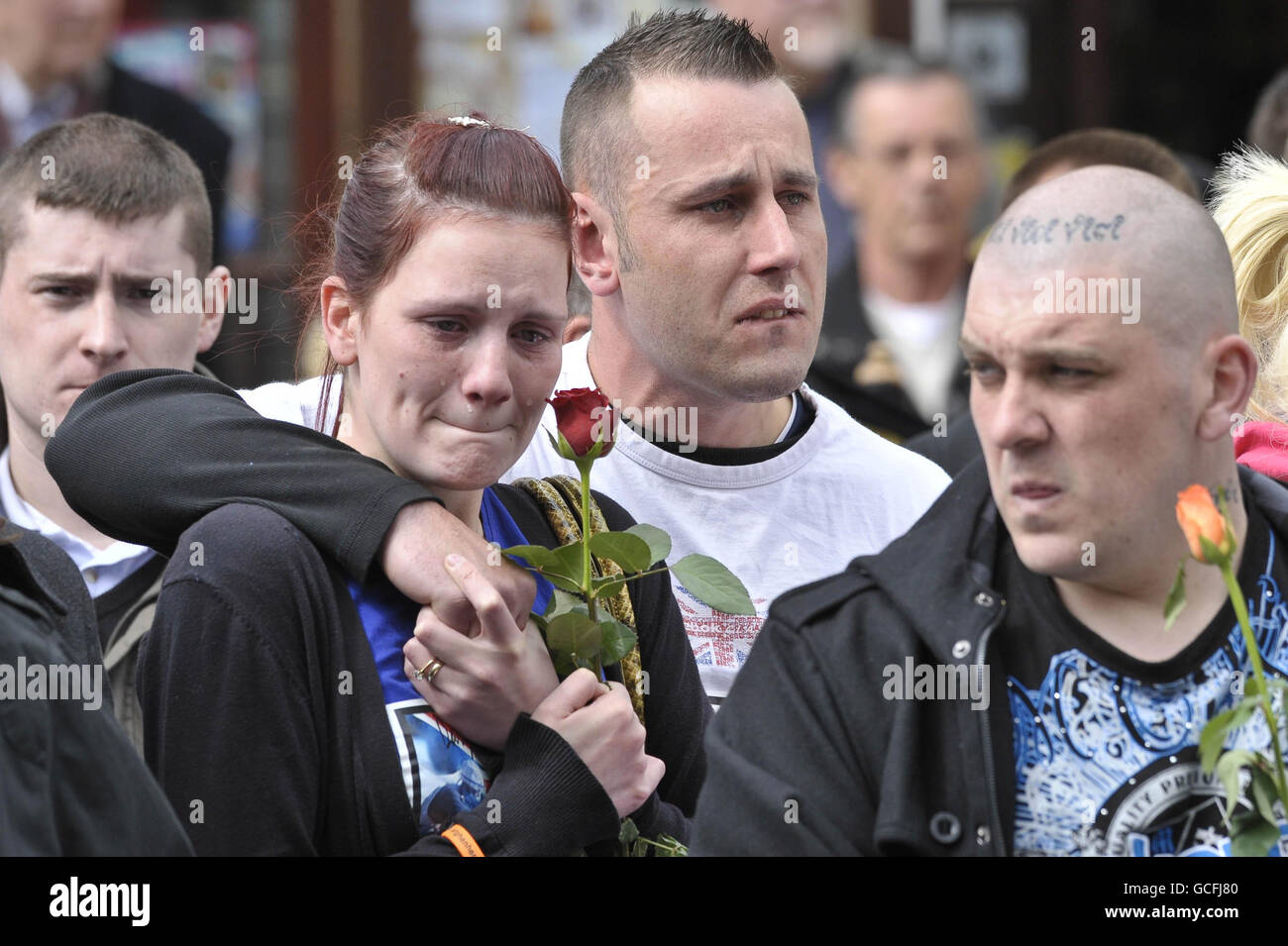 Mourners watch as hearses containing the coffins of Sapper Daryn Roy, Lance Corporal Barry Buxton and Corporal Harvey Holmes pass through the town of Wootton Bassett after their repatriation at RAF Lyneham in Wiltshire. Stock Photo