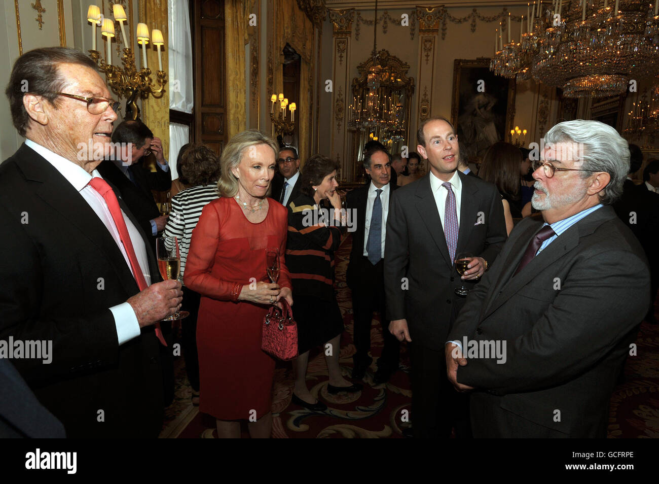 The Earl of Wessex (second right) meets Sir Roger Moore, his wife Kristina, and George Lucas (right) at a drinks reception for the 'Film without Borders' charity at Buckingham Palace in central London. Stock Photo