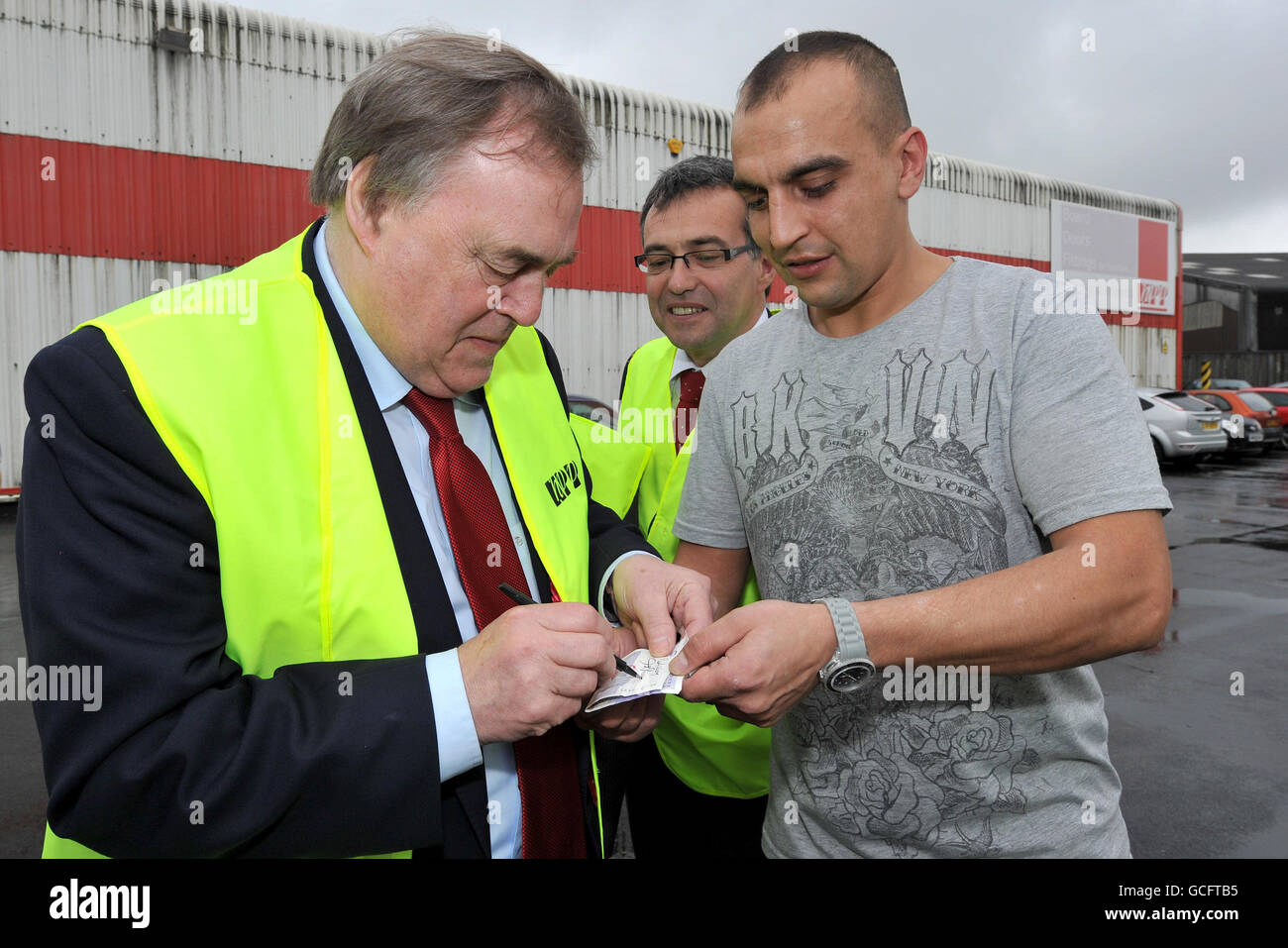 Former deputy Prime Minister John Prescott signs the 20 note of Tony Marsden (right), watched by Labour's candidate for Oldham East Phil Woolas during his visit to Hills Panel Products, Oldham. Stock Photo