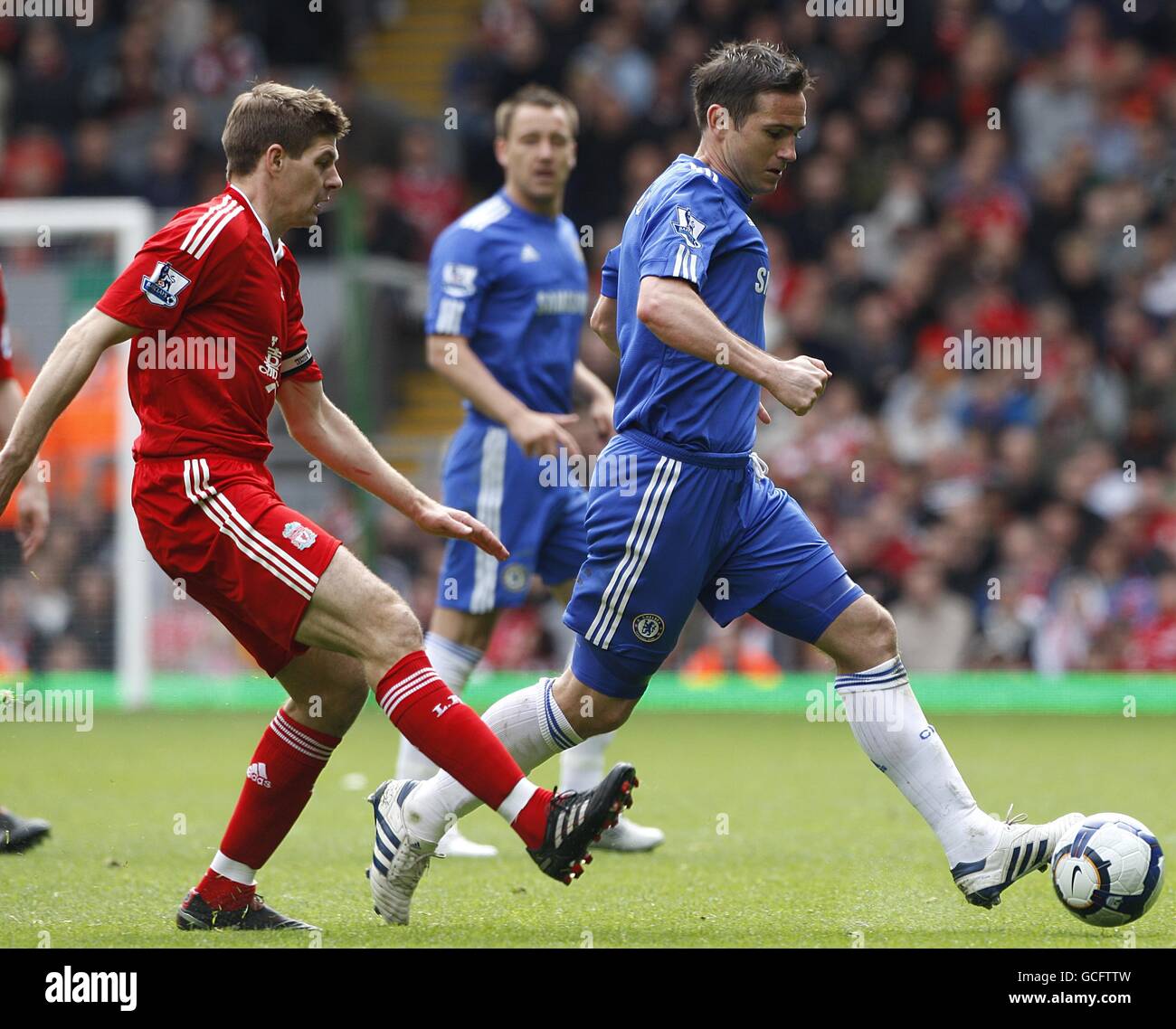 Liverpool's Steven Gerrard (left) and Frank Lampard (right) in action as Chelsea's John Terry (centre) looks on Stock Photo