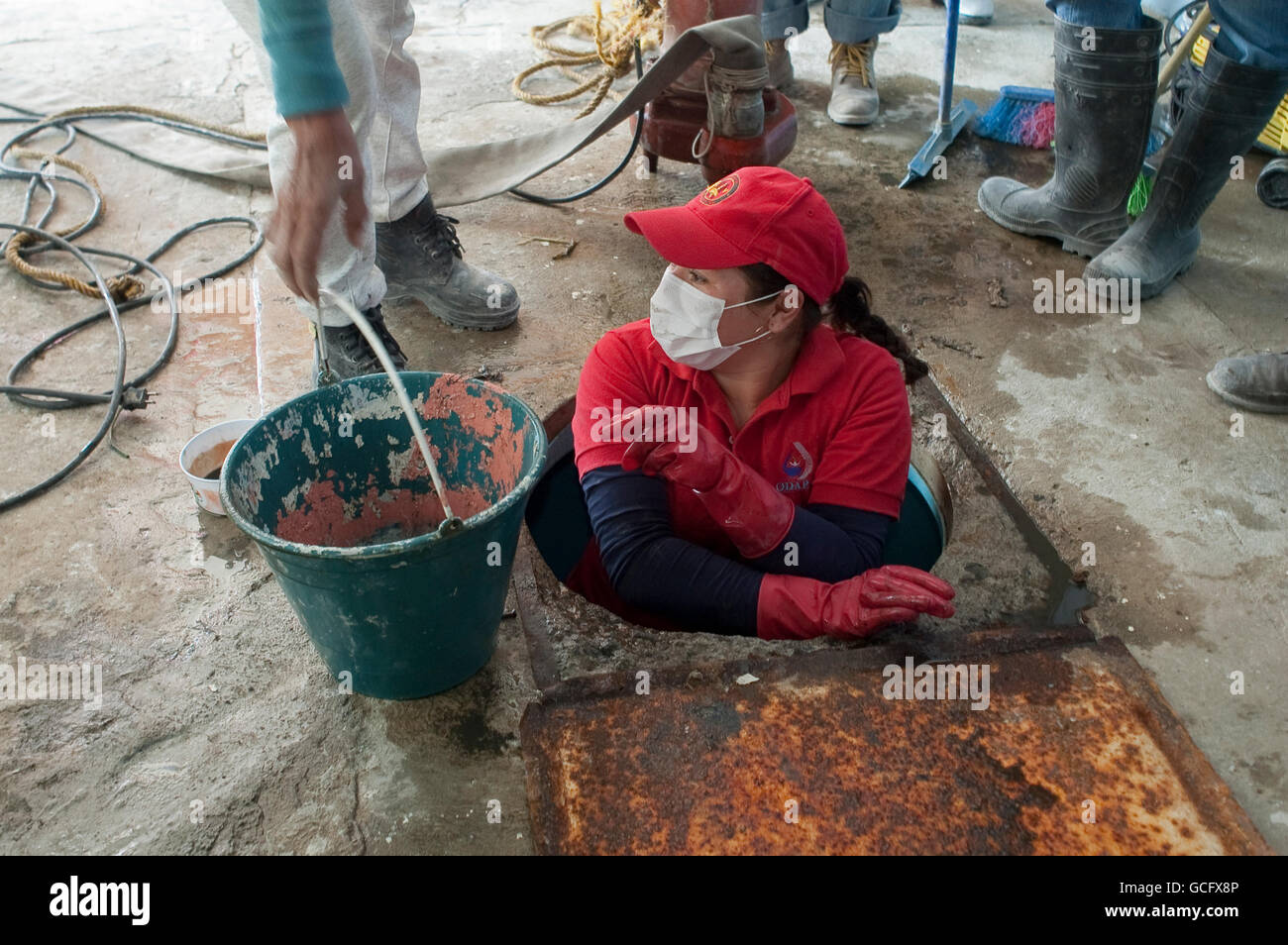 A municipal worker empties a household storage tank of sewage water after major flooding east of Mexico City. Stock Photo