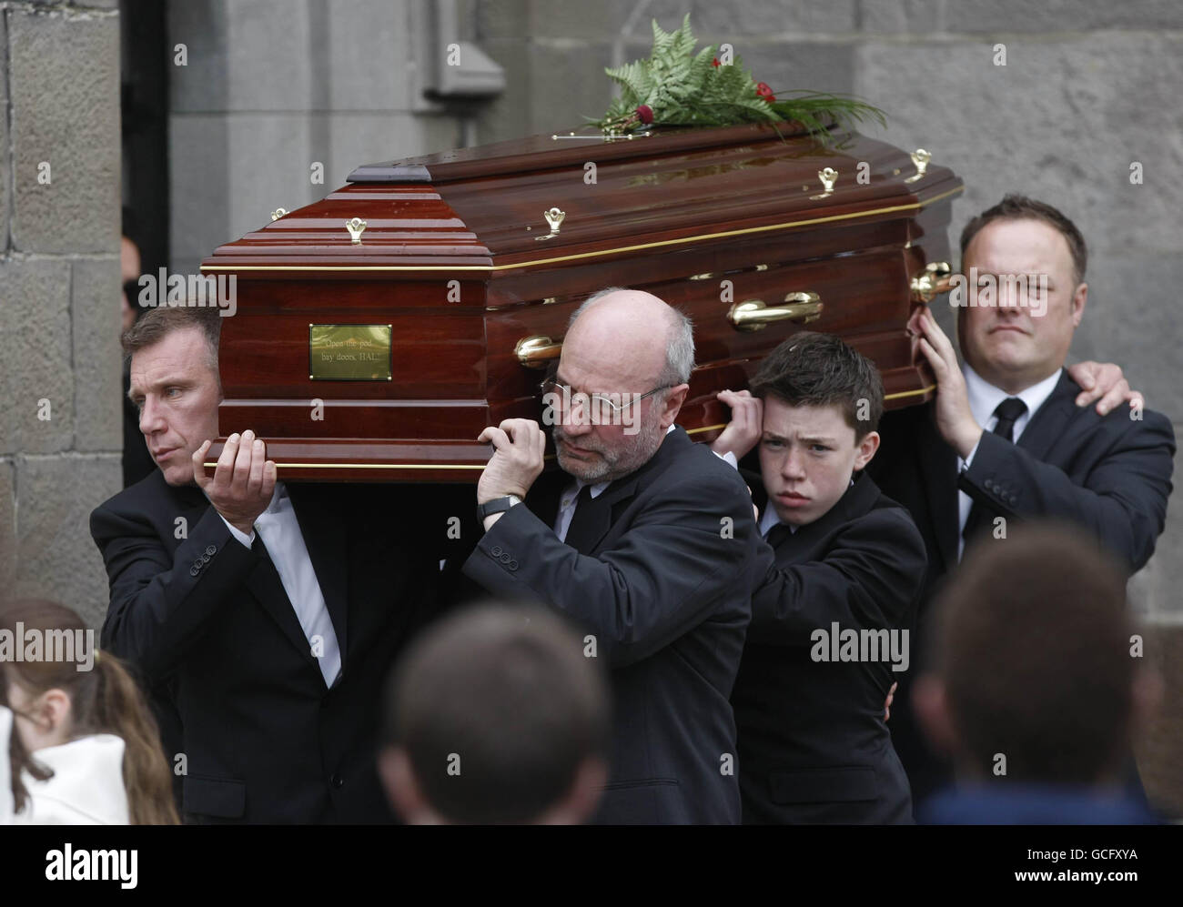 Gerry Ryan's coffin, inscribed with a quote from the movie' 2001 A Space Odyssey' is carried from St John the Baptist Church in Clontarf, Dublin, by his brother Mick (left) and his son Elliot (second right), following his funeral service. Stock Photo