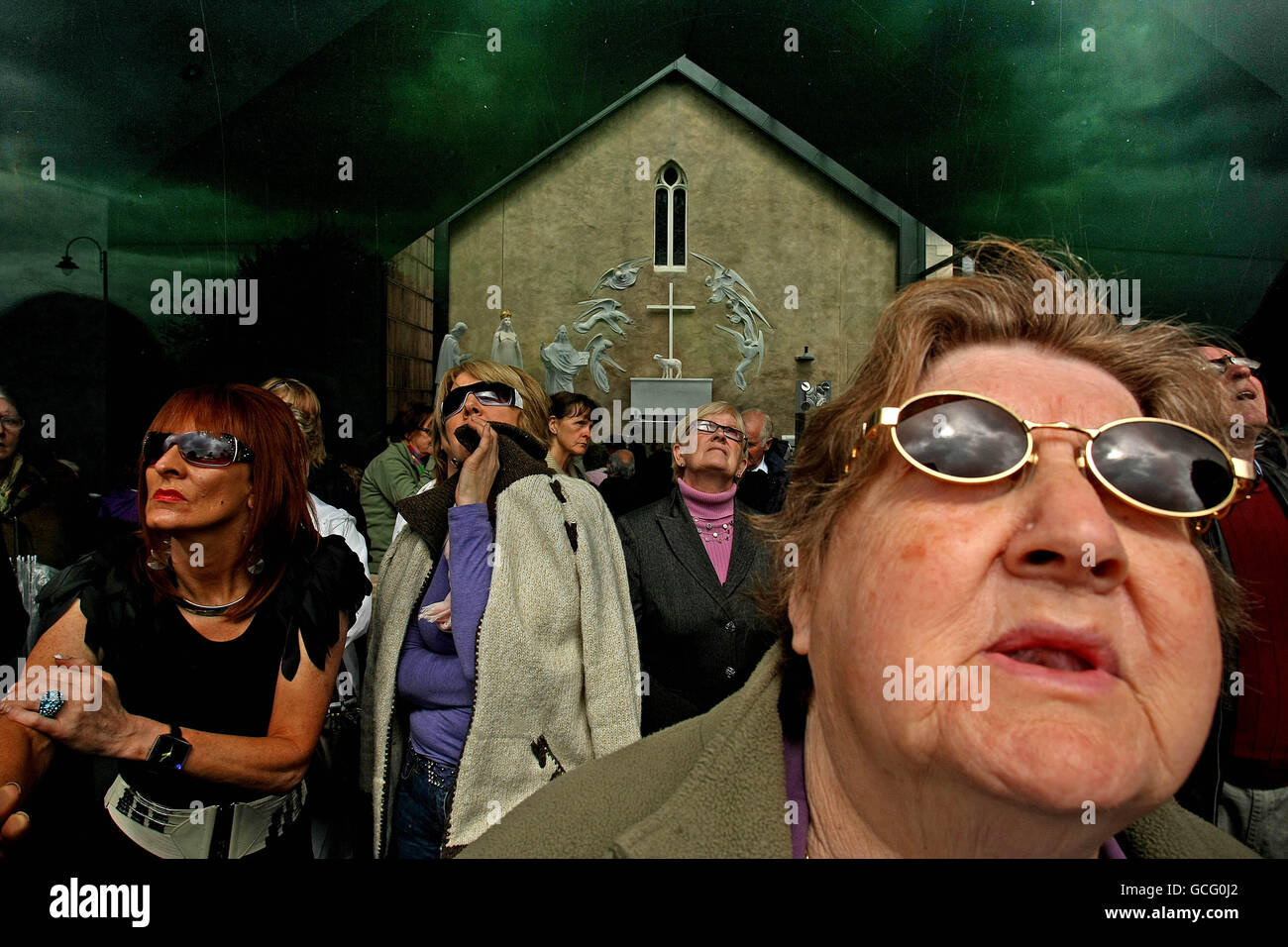 People wear sunglasses to protect their eyes from the sun as 'Visionary'  Joe Coleman from Dublin prays in Knock Shrine Co Mayo where he claims he  will witness a vision from the