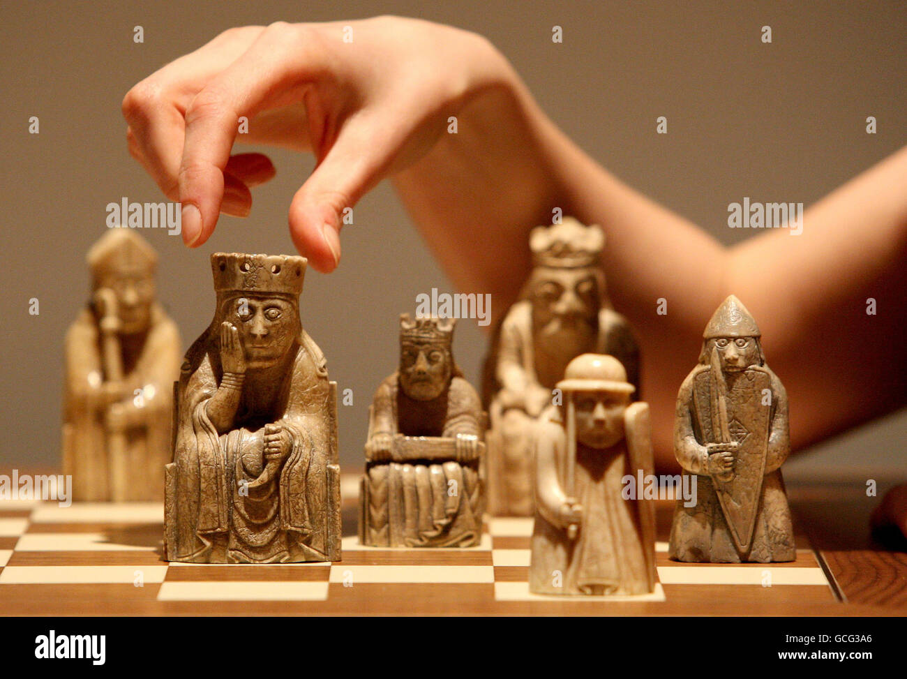 An employee with the Lewis Chessmen chess set at the National Museum of Scotland in Edinburgh. Stock Photo