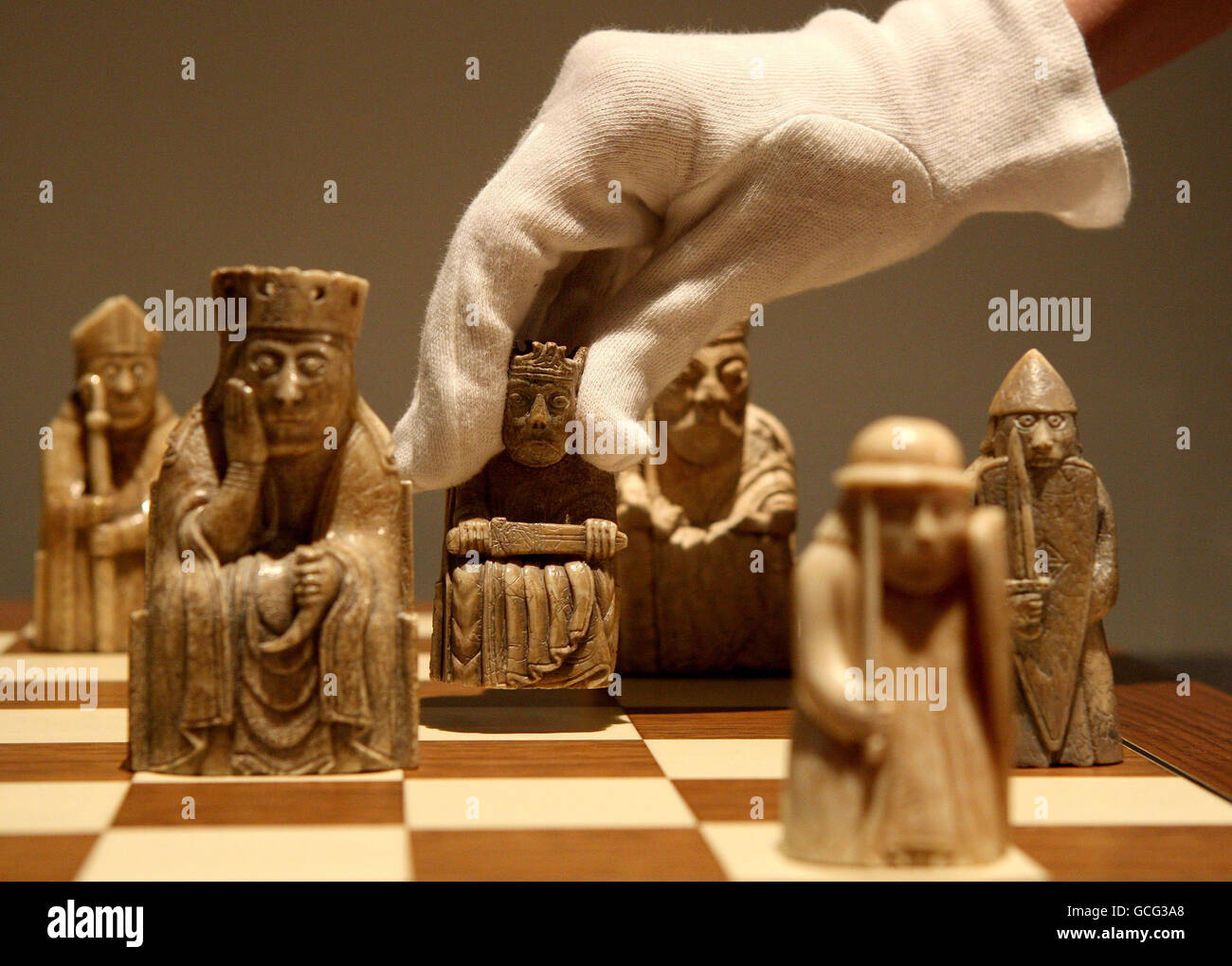 An employee with the Lewis Chessmen chess set at the National Museum of Scotland in Edinburgh. Stock Photo
