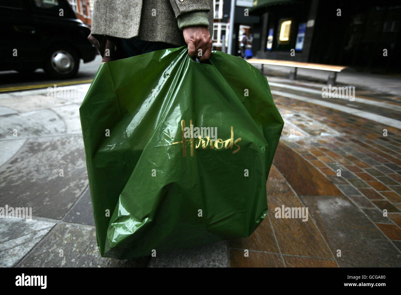 A shopper with a bag from the Harrods department store in London. The ...