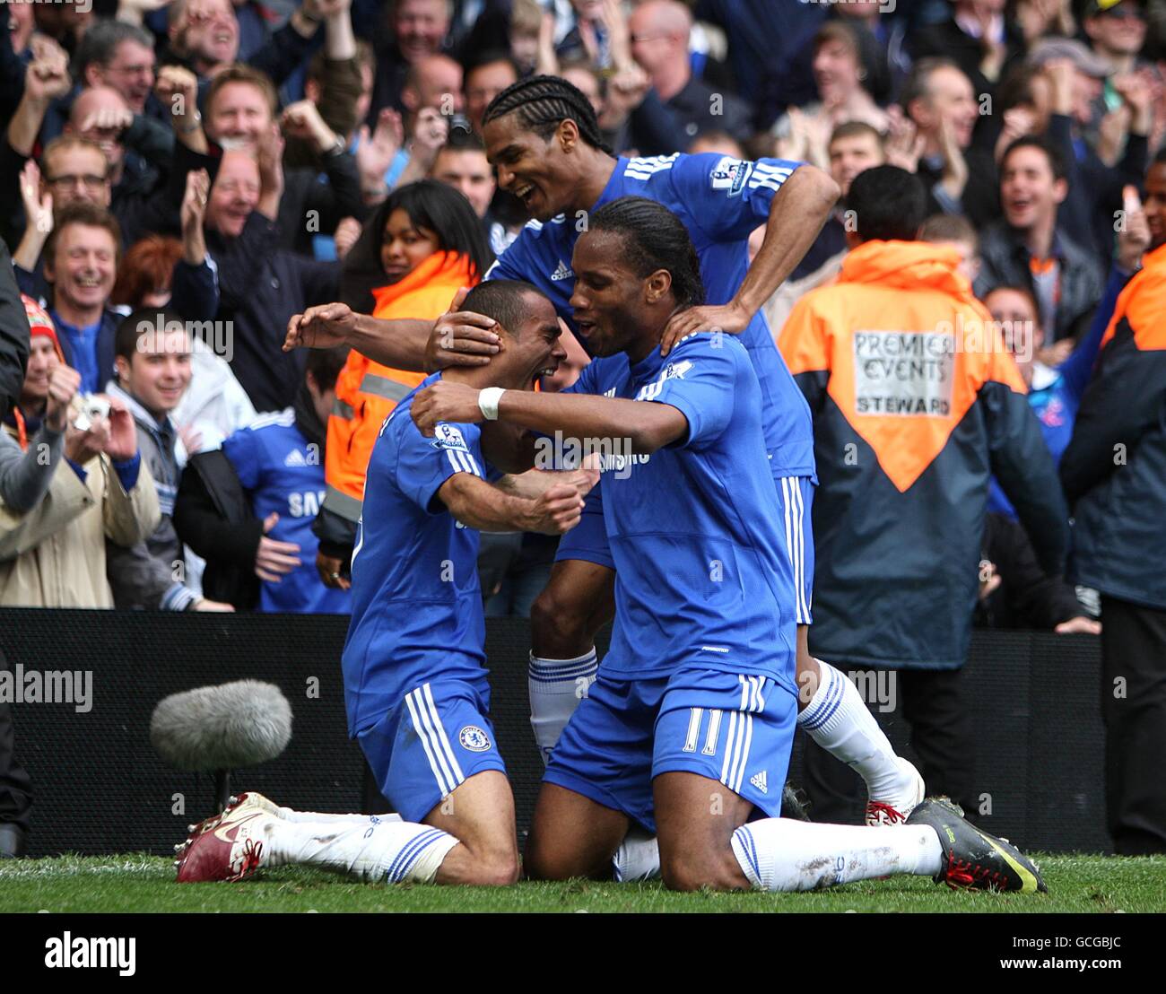 Soccer - Barclays Premier League - Chelsea v Wigan Athletic - Stamford Bridge. Chelsea's Ashley Cole (left) celebrates scoring with teammates Didier Drogba (right) and Florent Malouda (top) Stock Photo