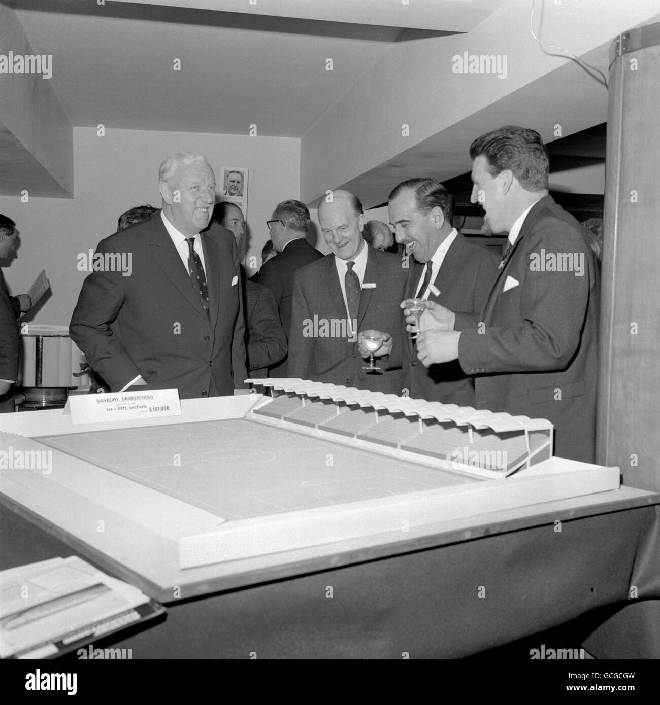 Sir Stanley Rous, President of FIFA, left, viewing a model of a sectionalised concrete grandstand which has been designed as a solution to soccer clubs' ground improvement problems. The six section model is similar to one at the Coventry City ground, and was on view at a cocktail party given at The Savoy Hotel, London, by Banbury Grandstands Ltd. Left to right: Sir Stanley Rous; Stan Cullis, general manager of Banbury Grandstands; Derek Robins, chairman of Coventry City FC, and Jimmy Hill, manager of Coventyr City, and a director of Banbury Grandstands. Stock Photo