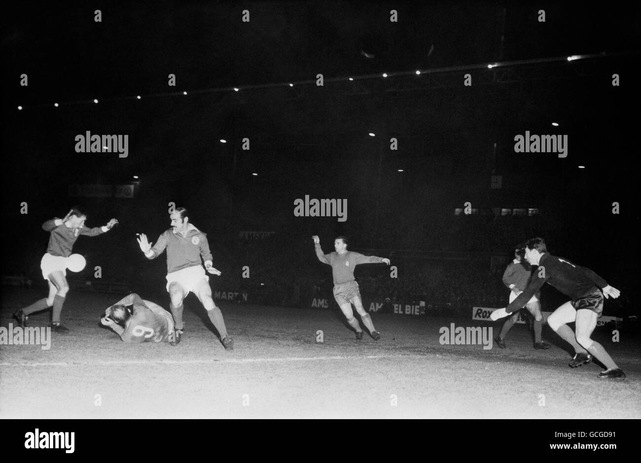 Benfica's Fernando Cruz (l) and Germano (3rd left) thwart Real Madrid's Alfredo Di Stefano (on floor) during an attack watched by Real Madrid's Ferenc Puskas (4th left) and Benfica goalkeeper Alberto da Costa Pereira (r). The game finished 5-3 to Benfica. Stock Photo