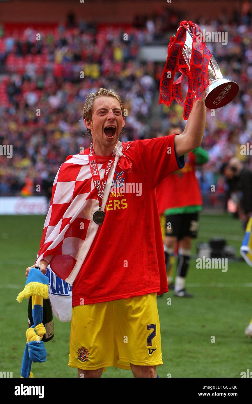 hjerne Opdatering alder Dagenham & Redbridge goal scorer Danny Green celebrates with the Coca-Cola  Football League Two Play Off trophy after the final whistle Stock Photo -  Alamy