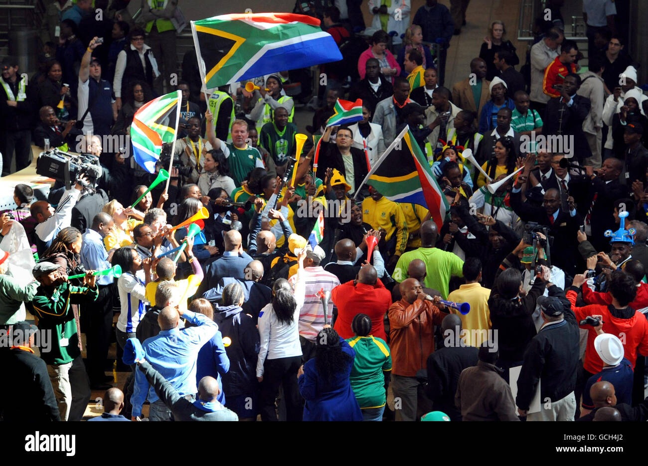 Fans blow horns and dance in Tambo Airport as fans begin to arrive